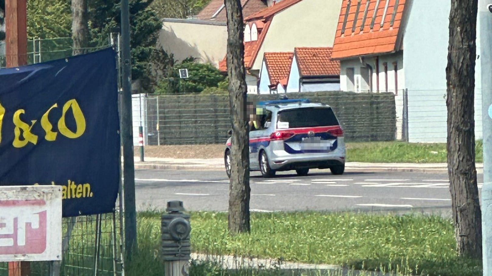 Mitten auf der Straße hielt ein Streifenwagen, ein Polizist lehnte sich aus dem Fenster.