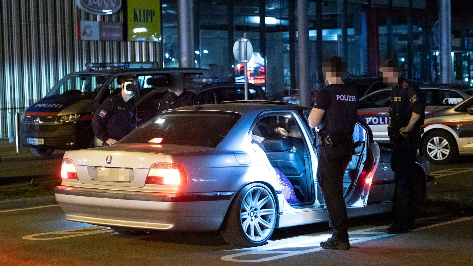 Polizisten kontrollieren einen BMW-Lenker.