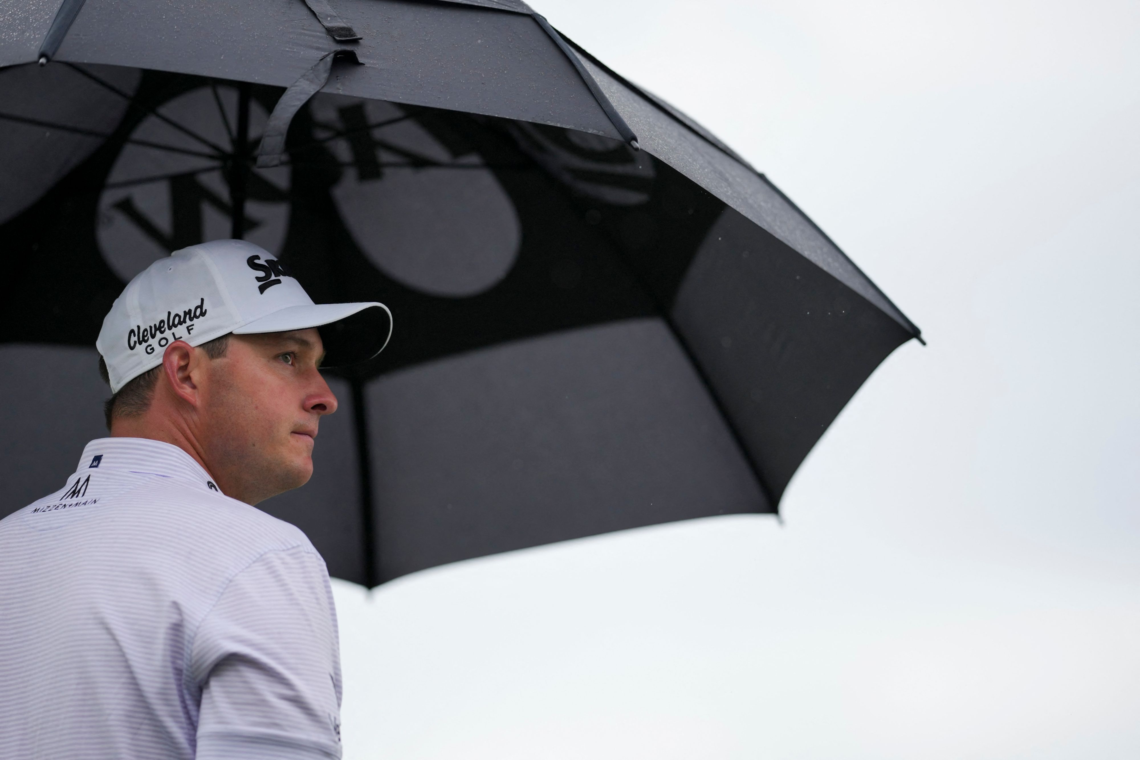 Straka geschützt unter einem Regenschirm.