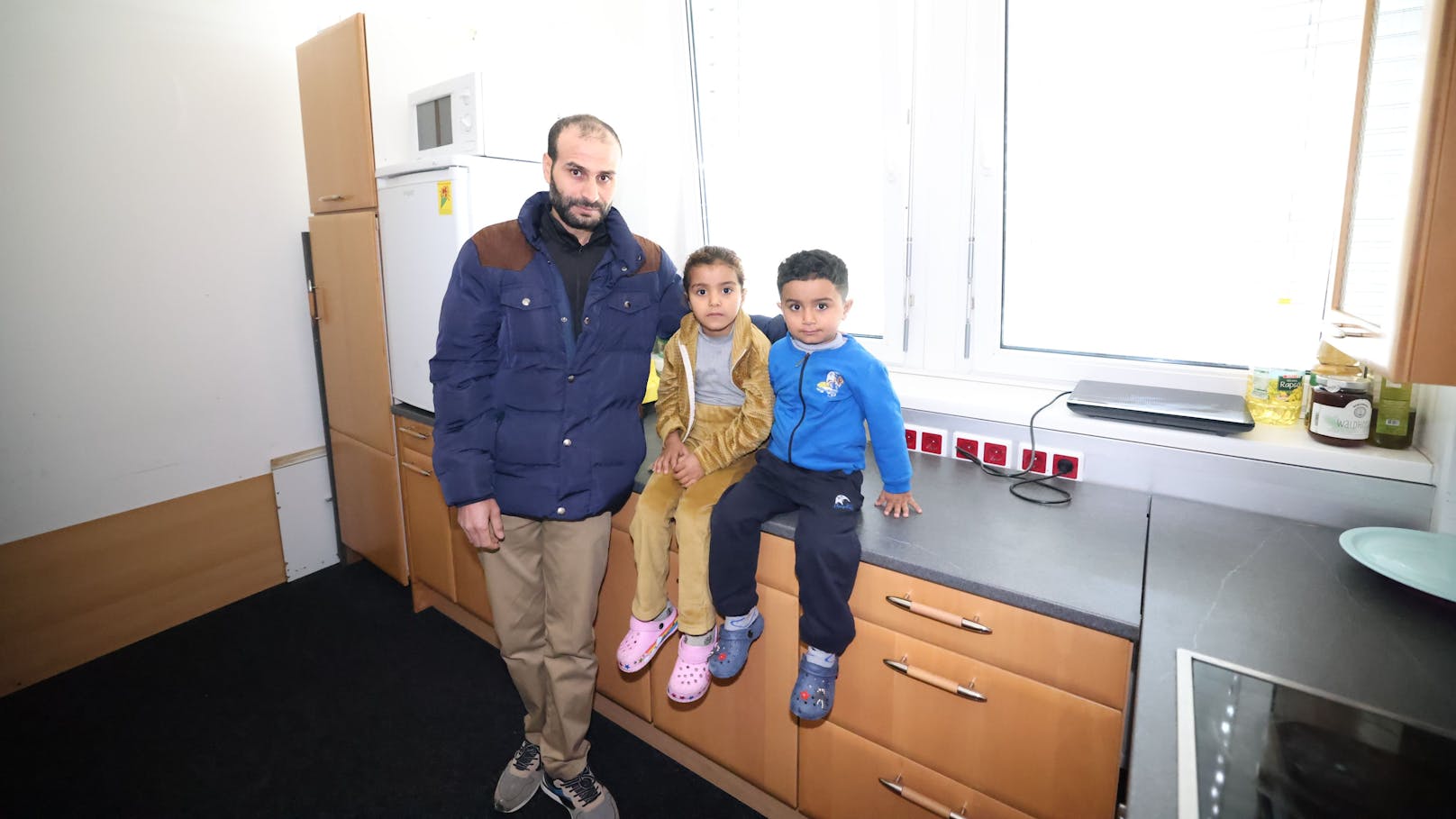 Abdulla M. (34) mit seinen beiden Söhnen Hajar (5) und Azam (3) zeigt seine Wohnung her – in der Küche kann nichts gekocht werden.