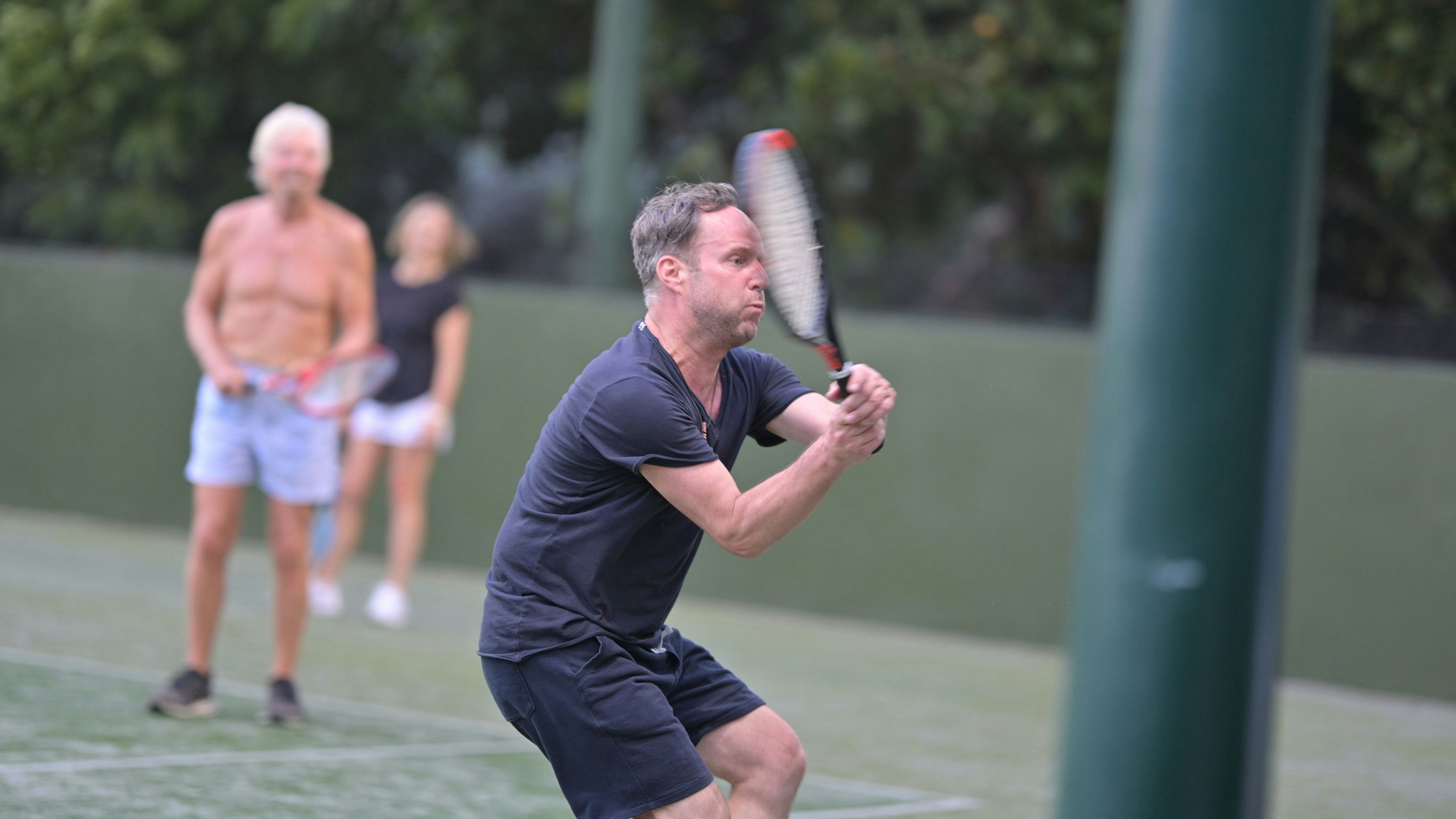 Hart am Netz: Matthias Strolz während einer Tennis-Session mit dem britischen Selfmade-Milliardär, der sich mit nacktem Oberkörper eher im Hintergrund hielt