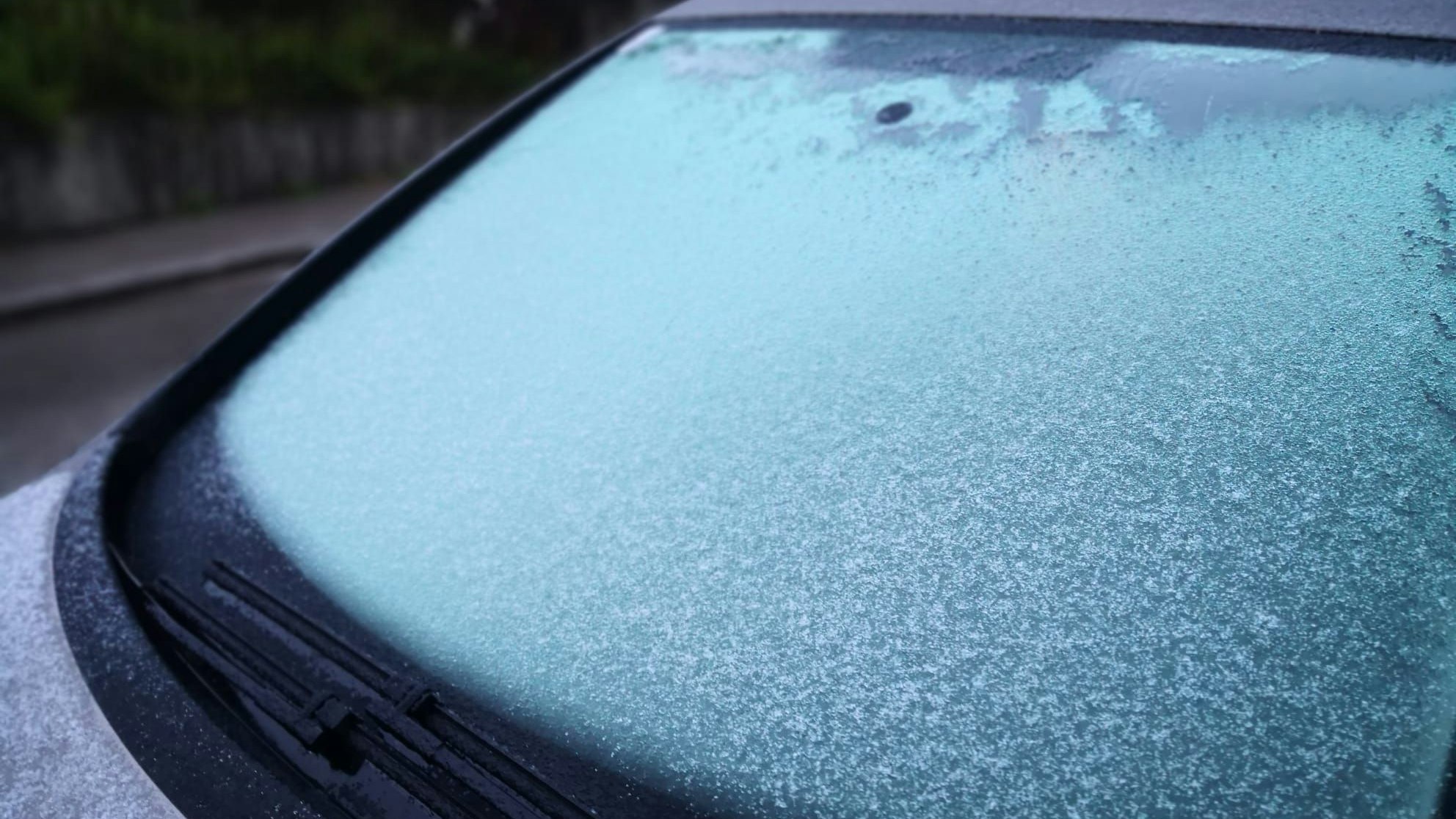 Klamme Wetterkapriole: Eine dünne Schneedecke bei gleichzeitigem Regen auf einer Autoscheibe im Wiener Umland am 23. April 2024.