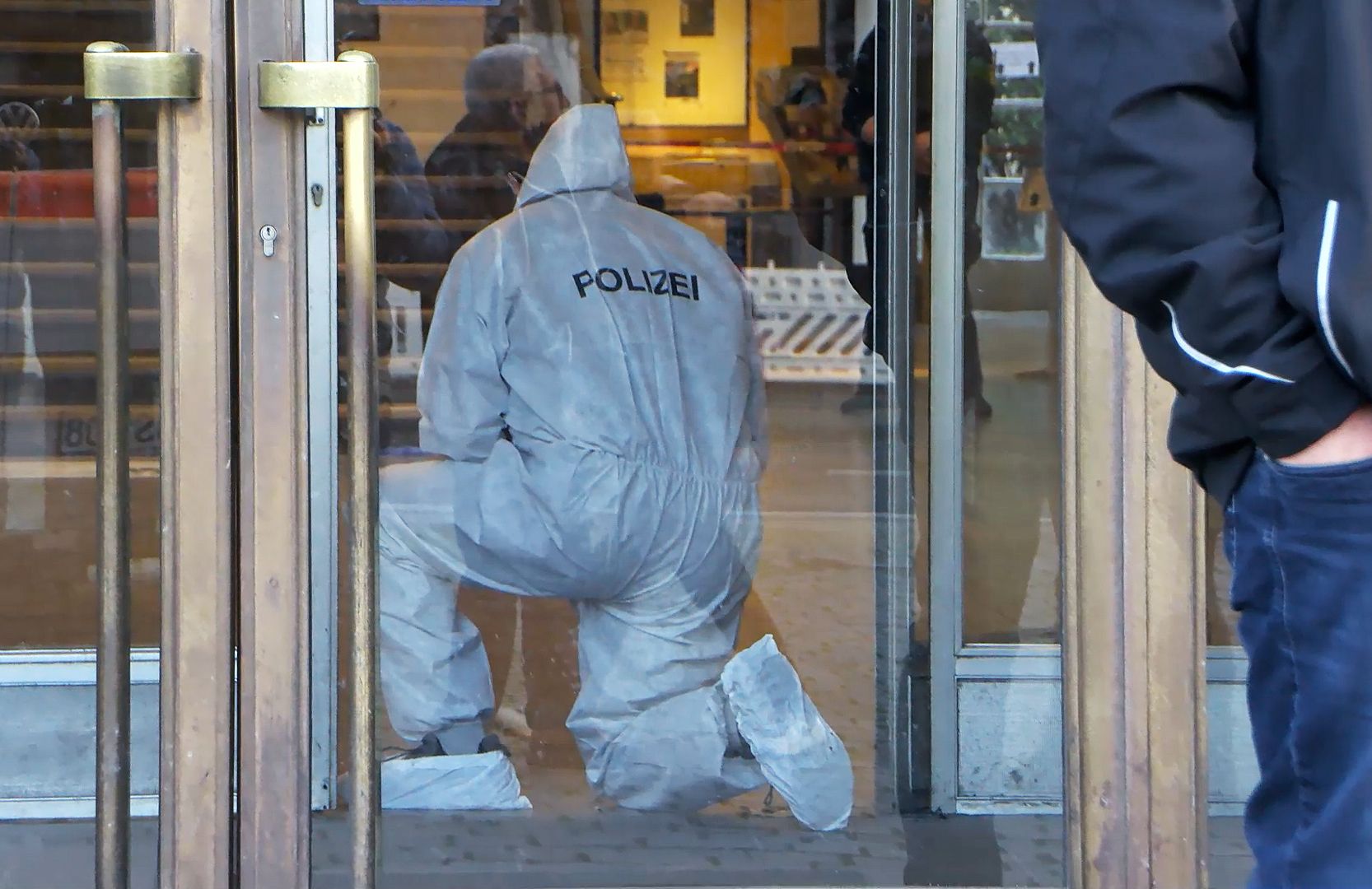 Ein Mitarbeiter der Spurensicherung der Polizei ist nach tödlichen Schüssen auf einen Macheten-Mann an der Universität in Mannheim im Einsatz. (23. April 2024)