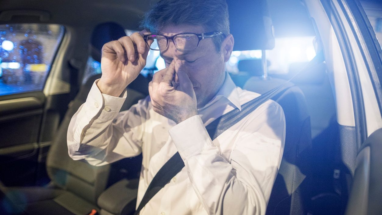 Tired driver inside car at night