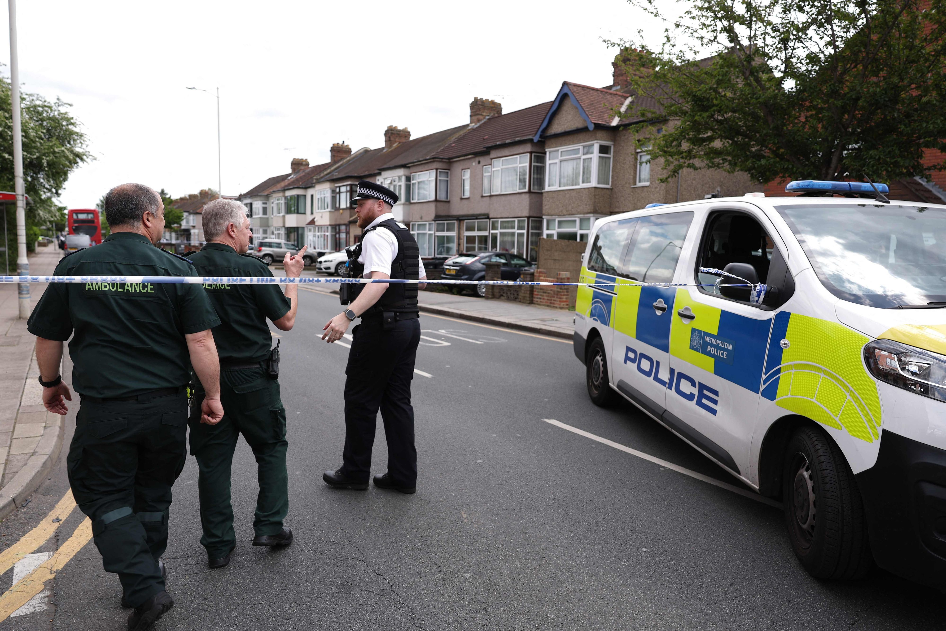 Ein Polizeibeamter spricht mit Sanitätern an einem Tatort in Hainault, östlich von London, wo ein 36-jähriger Mann mit einem Schwert Bürger sowie zwei Polizeibeamte angriff.