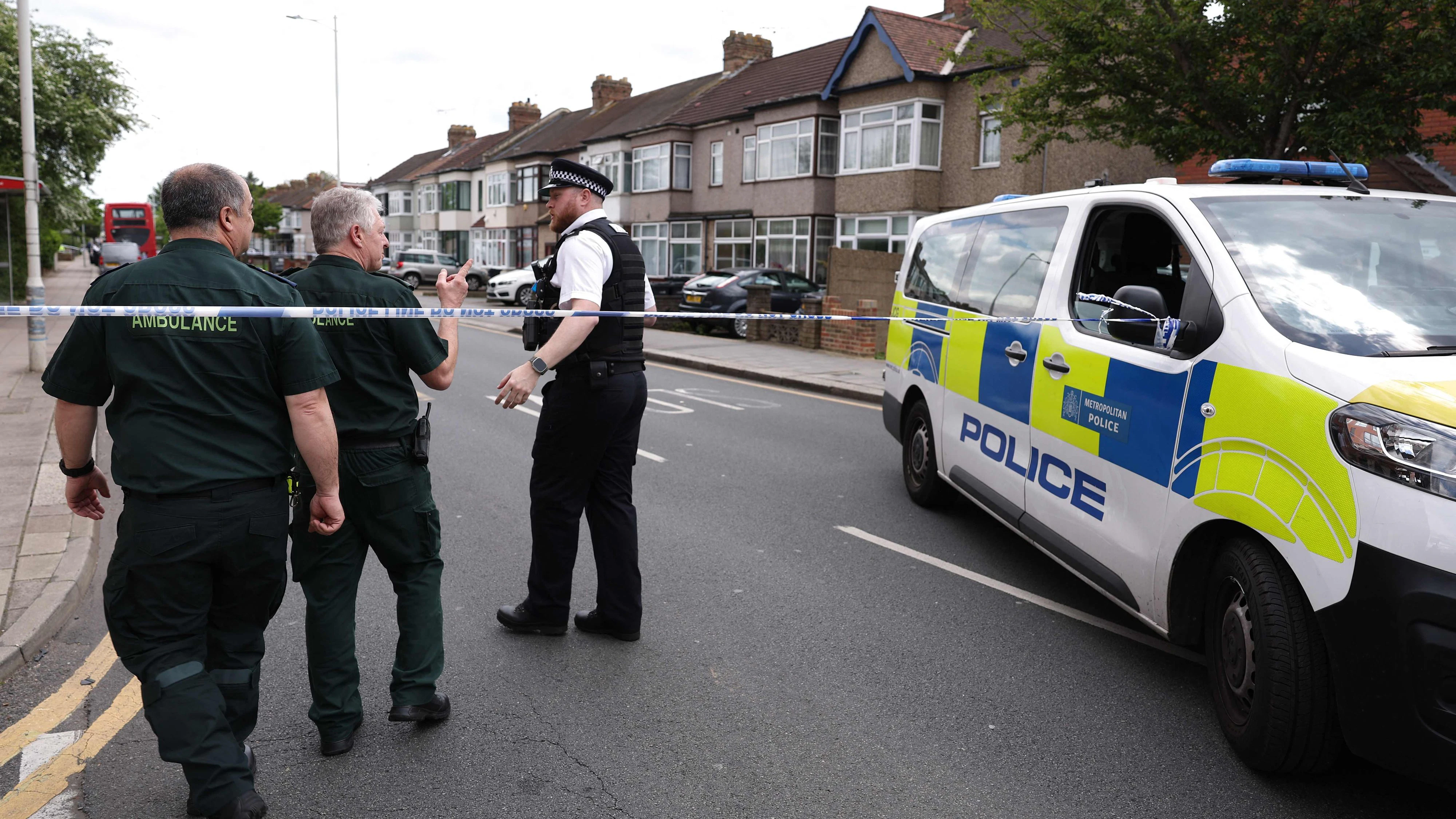 Ein Polizeibeamter spricht mit Sanitätern an einem Tatort in Hainault, östlich von London, wo ein 36-jähriger Mann mit einem Schwert Bürger sowie zwei Polizeibeamte angriff.