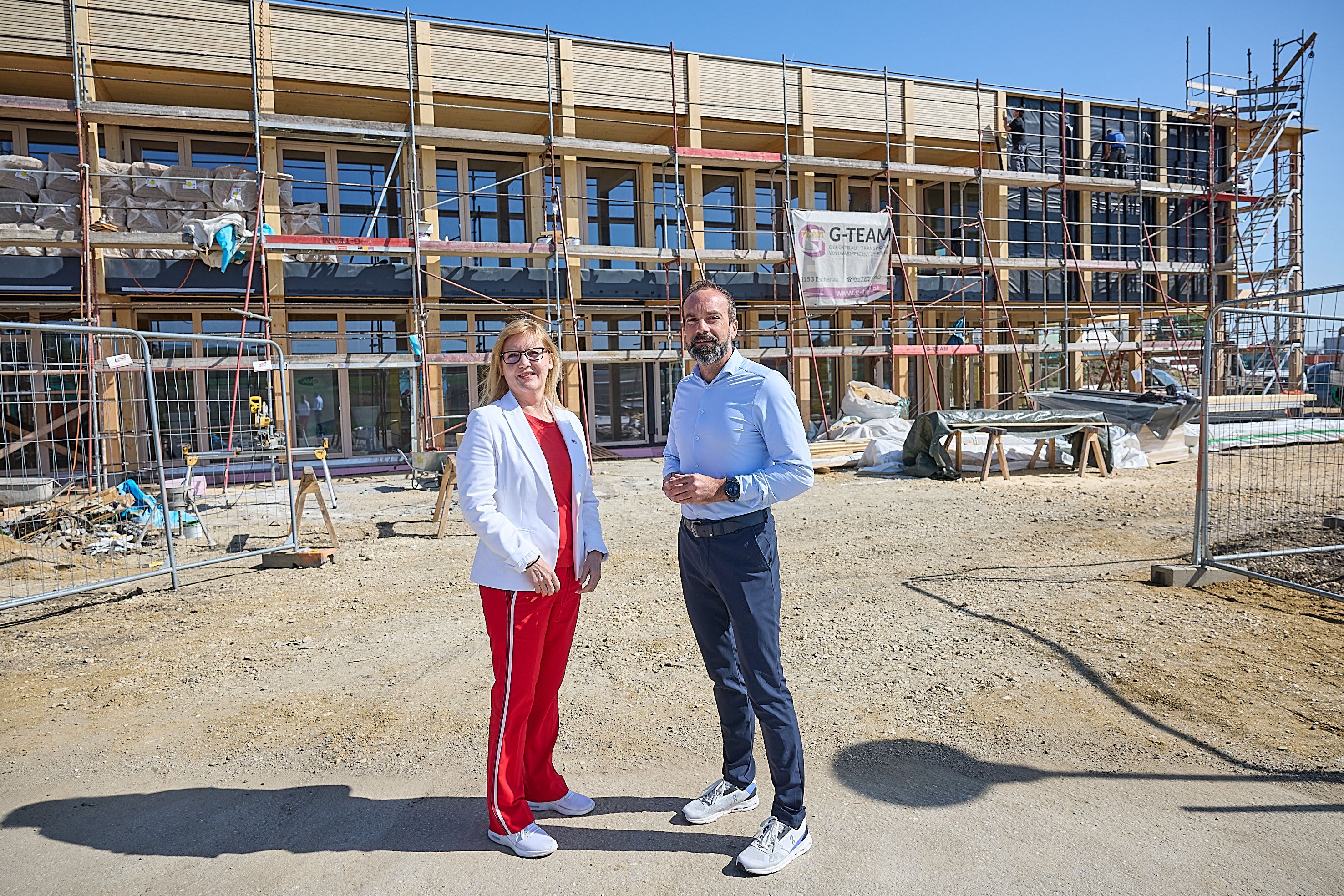 Sandra Kern, (LGF AMS NÖ), Markus Winter  (Vorst. Technik Windkraft Simonsfeld AG) vor der Baustelle des Erweiterungsbaus der Firmenzentrale.