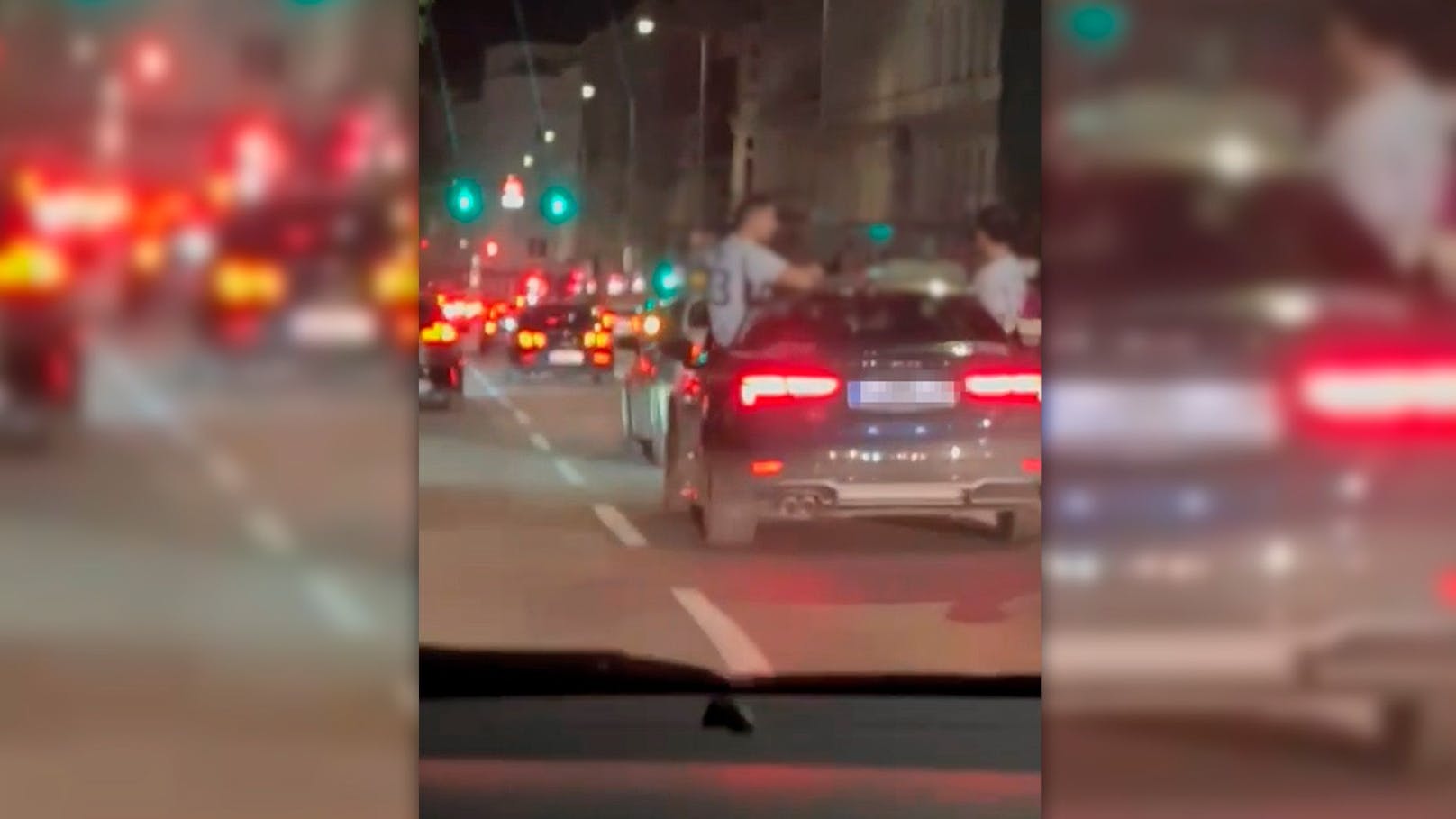 Männer sitzen auf Audi – Fahrer rast über den Gürtel