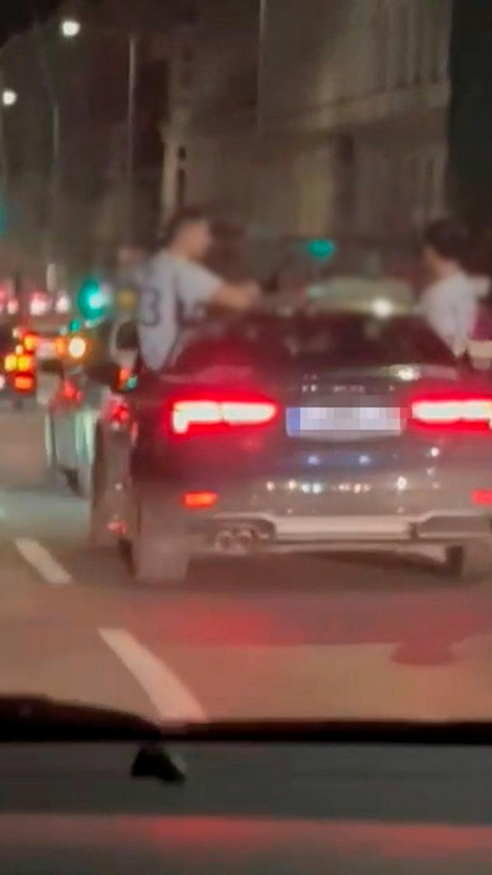 Männer sitzen auf Audi – Fahrer rast über den Gürtel