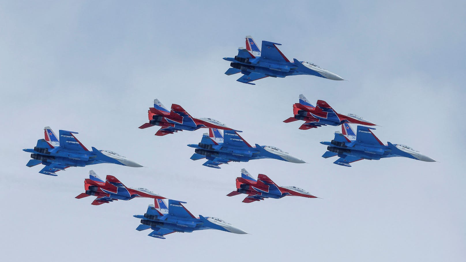 MiG-29-Düsenjäger der russischen Armee und Su-30SM-Düsenjäger der Kunstflugstaffel fliegen bei der Militärparade über dem Roten Platz.