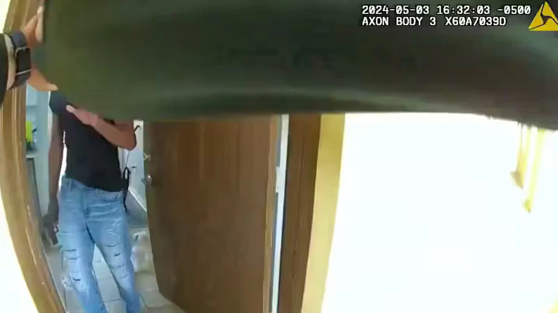 Auf Aufnahmen der Bodycam des Polizisten ist zu sehen, wie Fortson die Tür mit einer Waffe in der Handy öffnet.