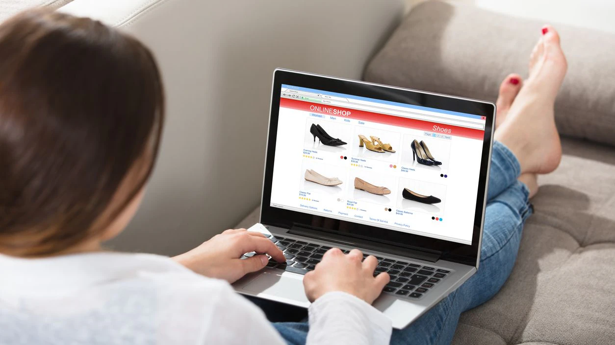 Woman Sitting On Couch Doing Online Shopping On Laptop