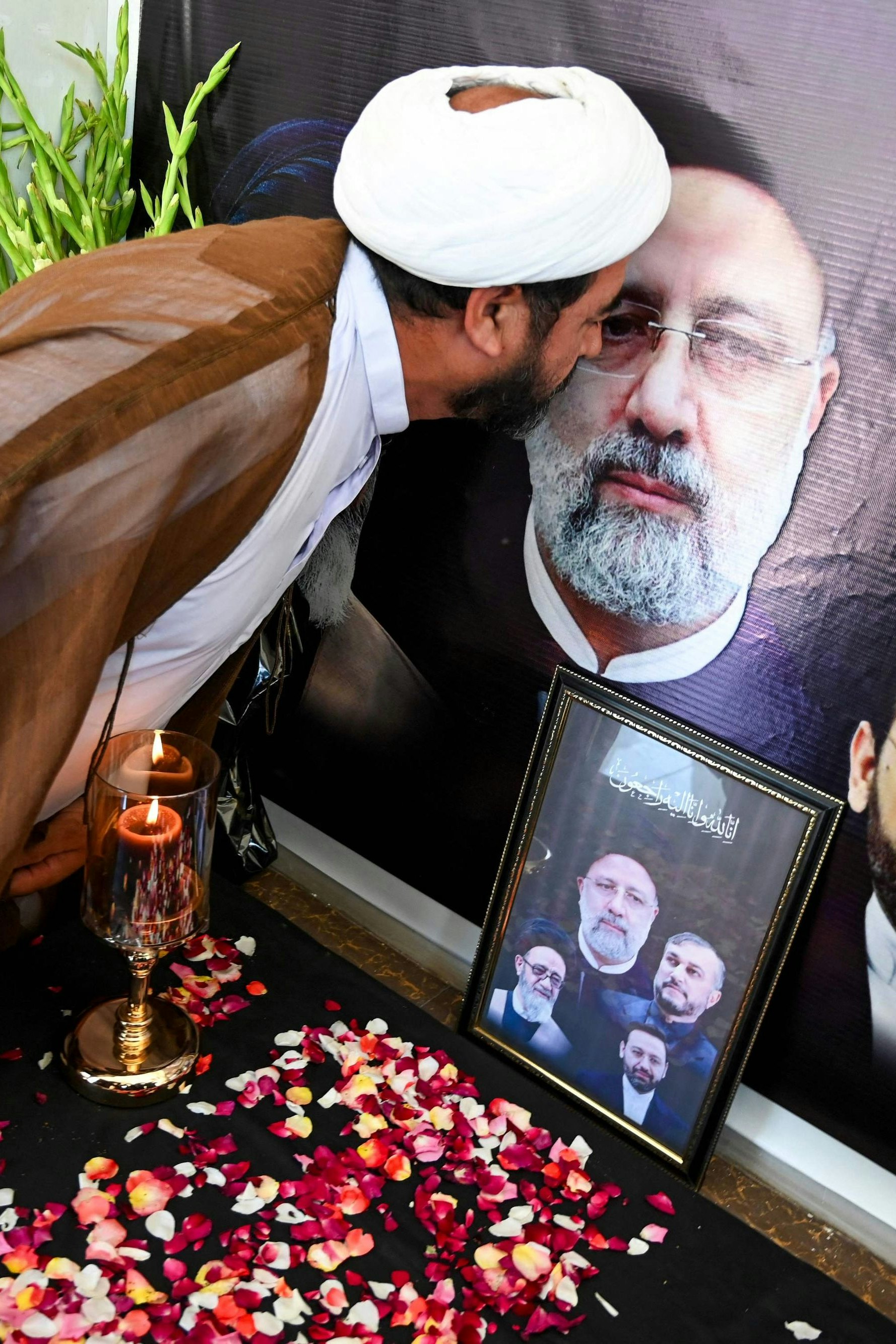 Ein Geistlicher küsst das Porträt von Irans verstorbenem Staatspräsidenten Ebrahim Raisi