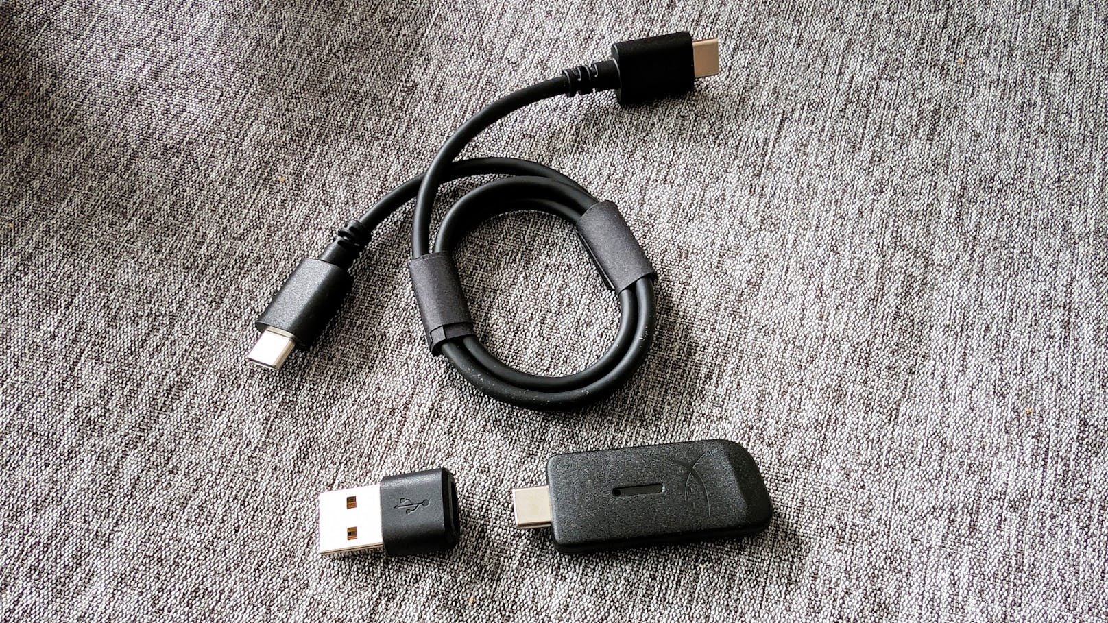 Mitgeliefert werden ein (mit knapp über einem halben Meter recht kurzes) USB-C-Ladekabel, ein ansteckbares Mikrofon, ...