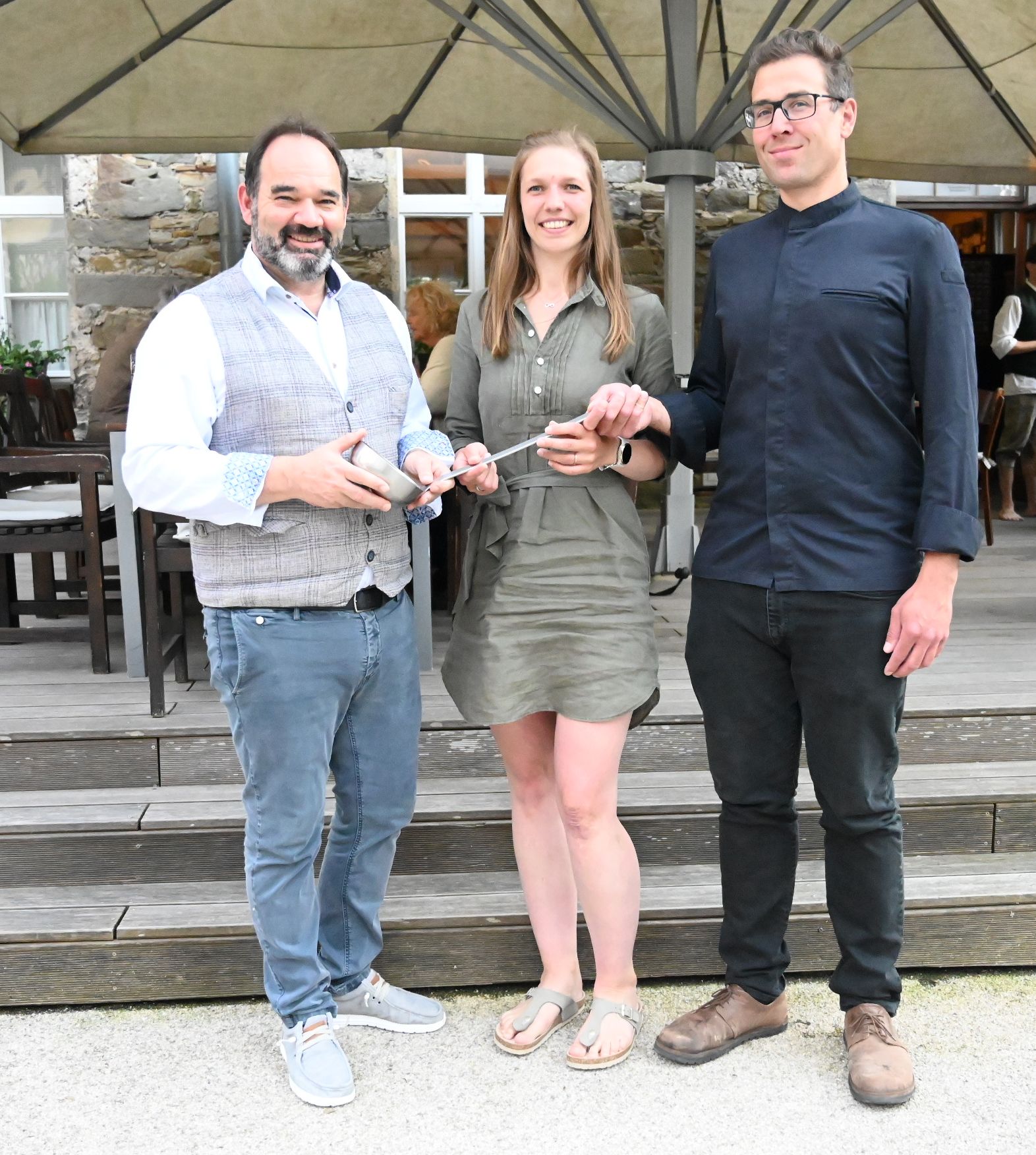 Andreas Plappert übergibt den Kochlöffel an das Ehepaar Vielhaber.