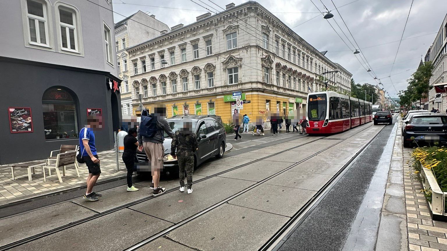 Mehrere Passanten versuchten, das kaputte Auto wegzuschieben.