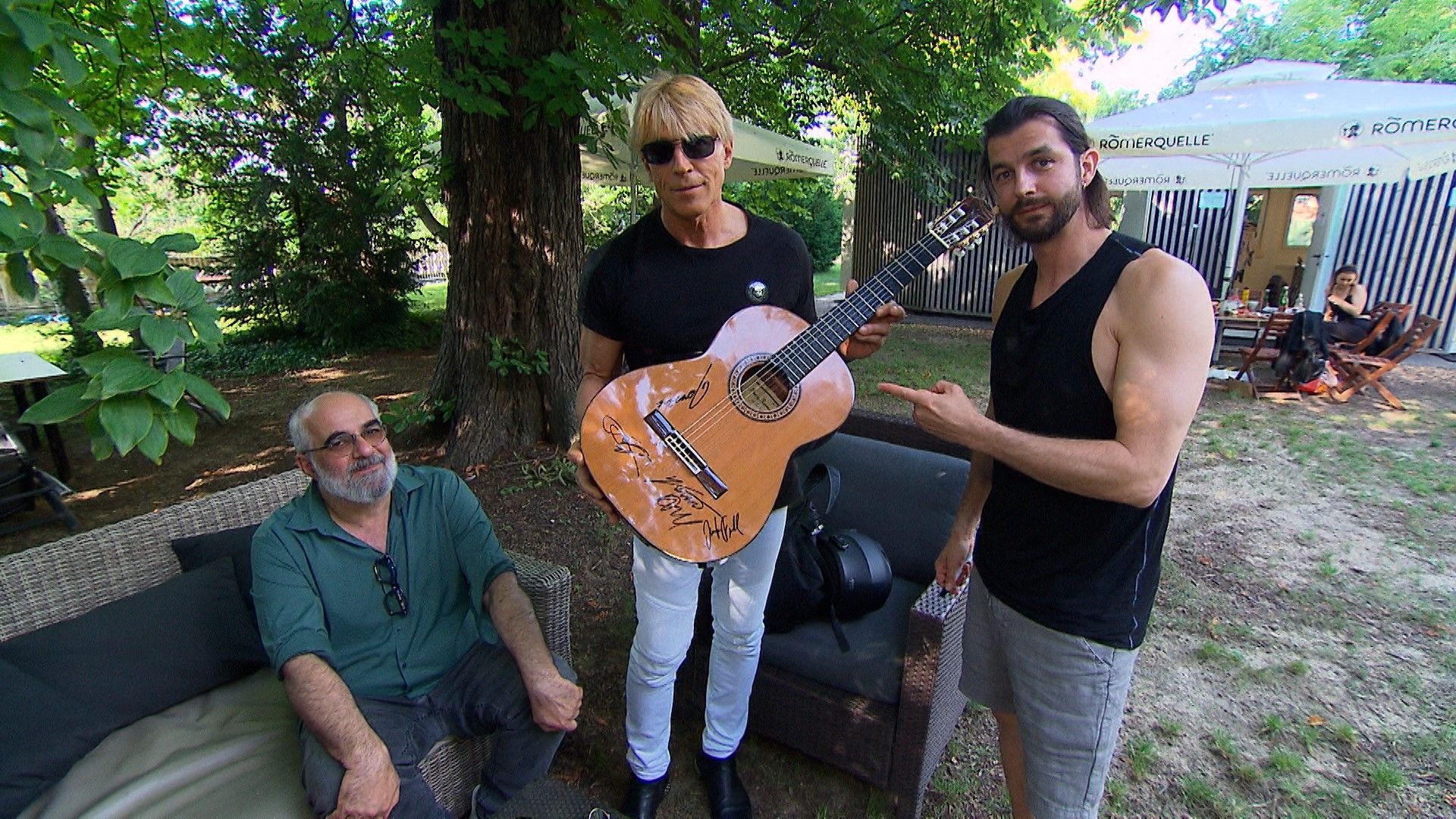 Michael Niavarani, Dominic Heinzl und Otto Jaus haben auf der Gitarre von Jaus unterschrieben