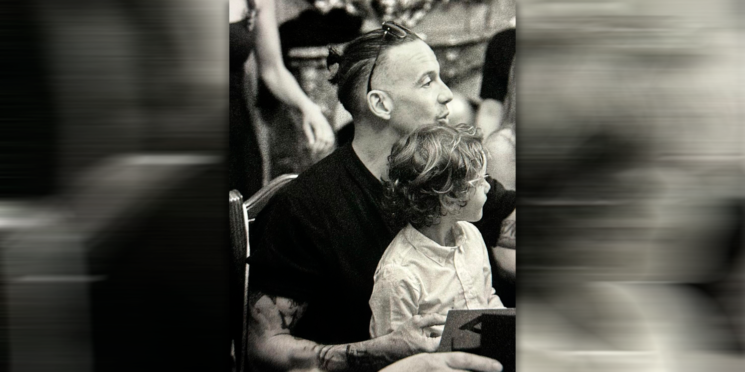 RAF Camora mit einem Kind auf dem Schoß.