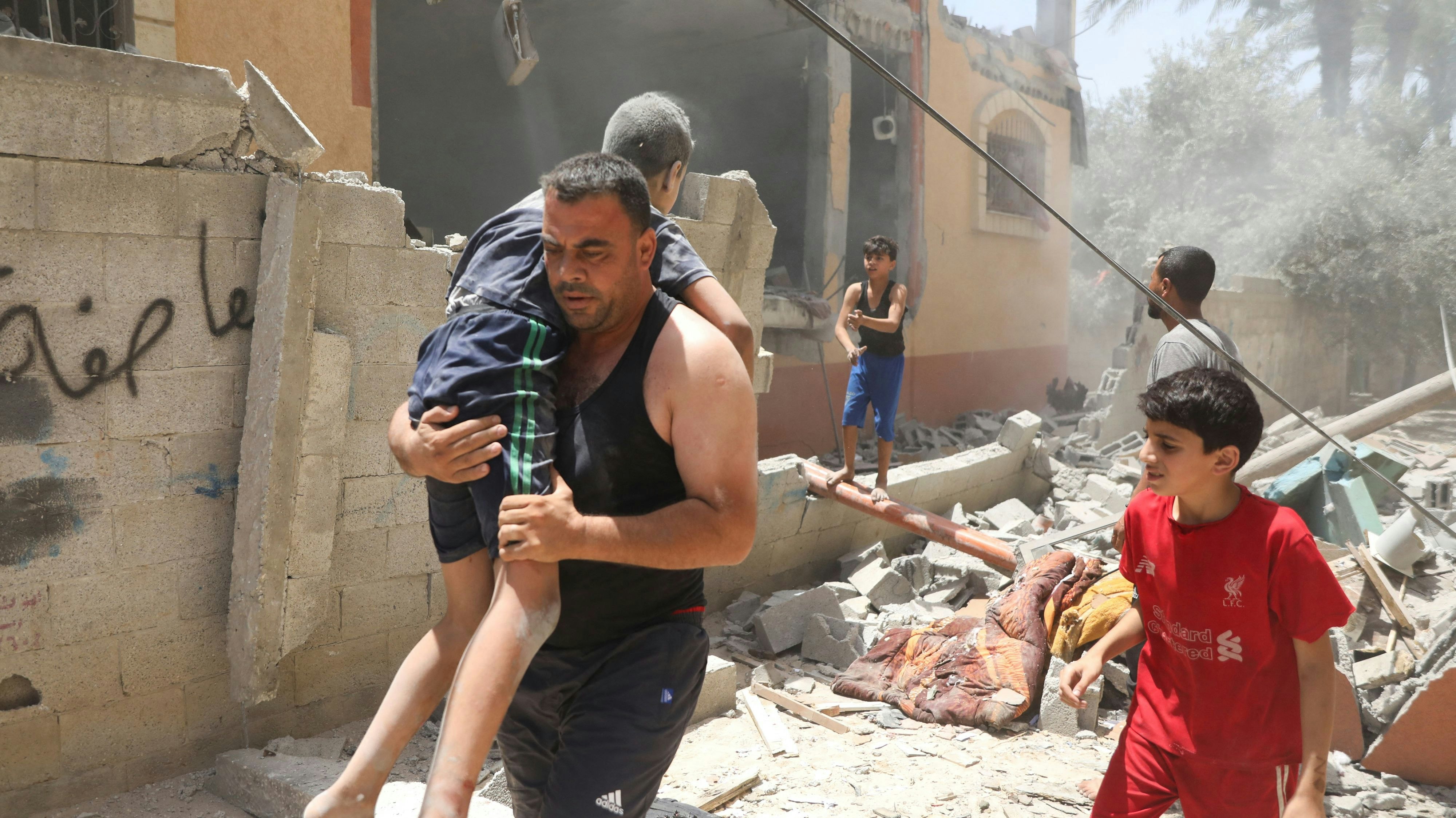 Ein palästinensischer Mann trägt ein verletztes Kind nach einem israelischen Angriff am Freitag im zentralen Gazastreifen.