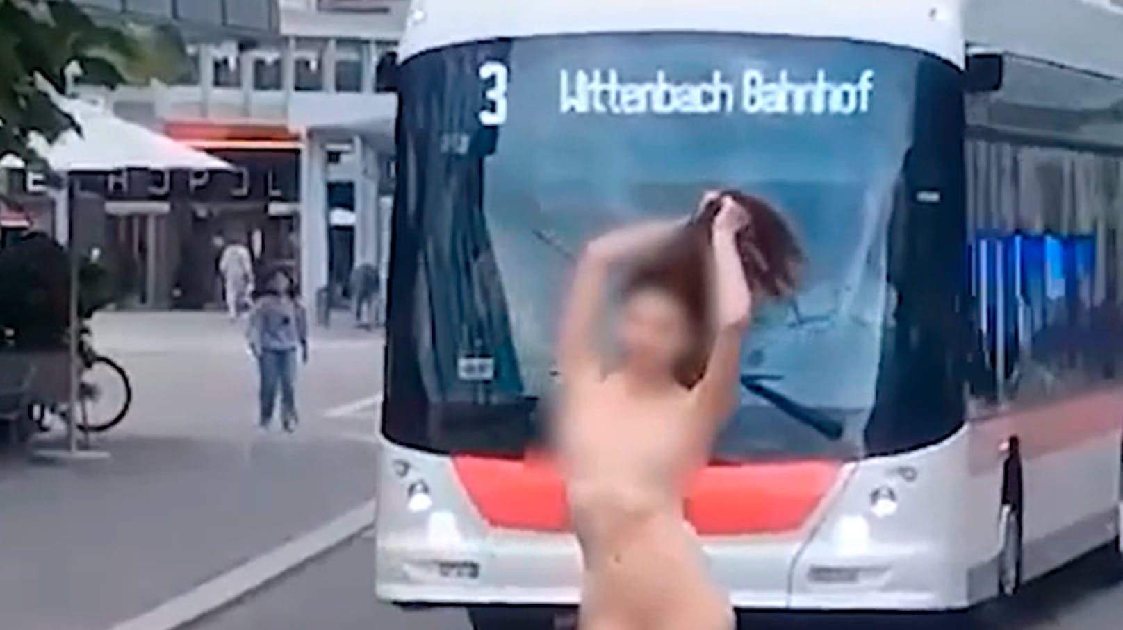 Junge Frau posiert am Bahnhof nackt für Kamera