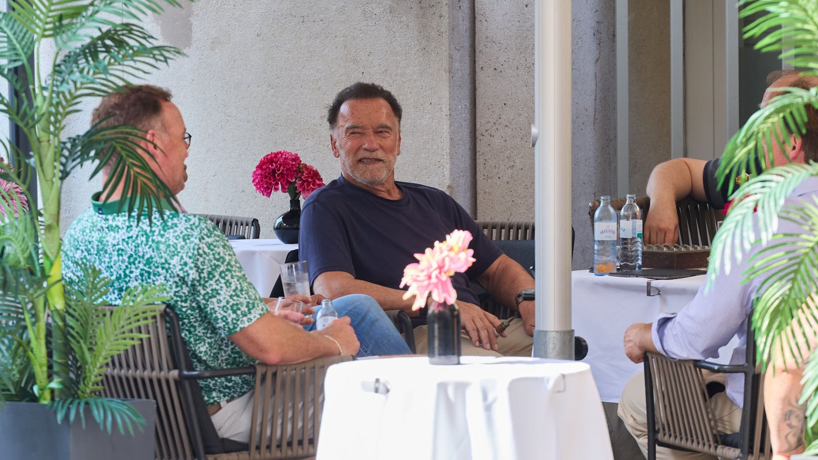 Arnie mischt sich im Café des Hotels unter die Gäste. In der Hand wieder eine Zigarre.