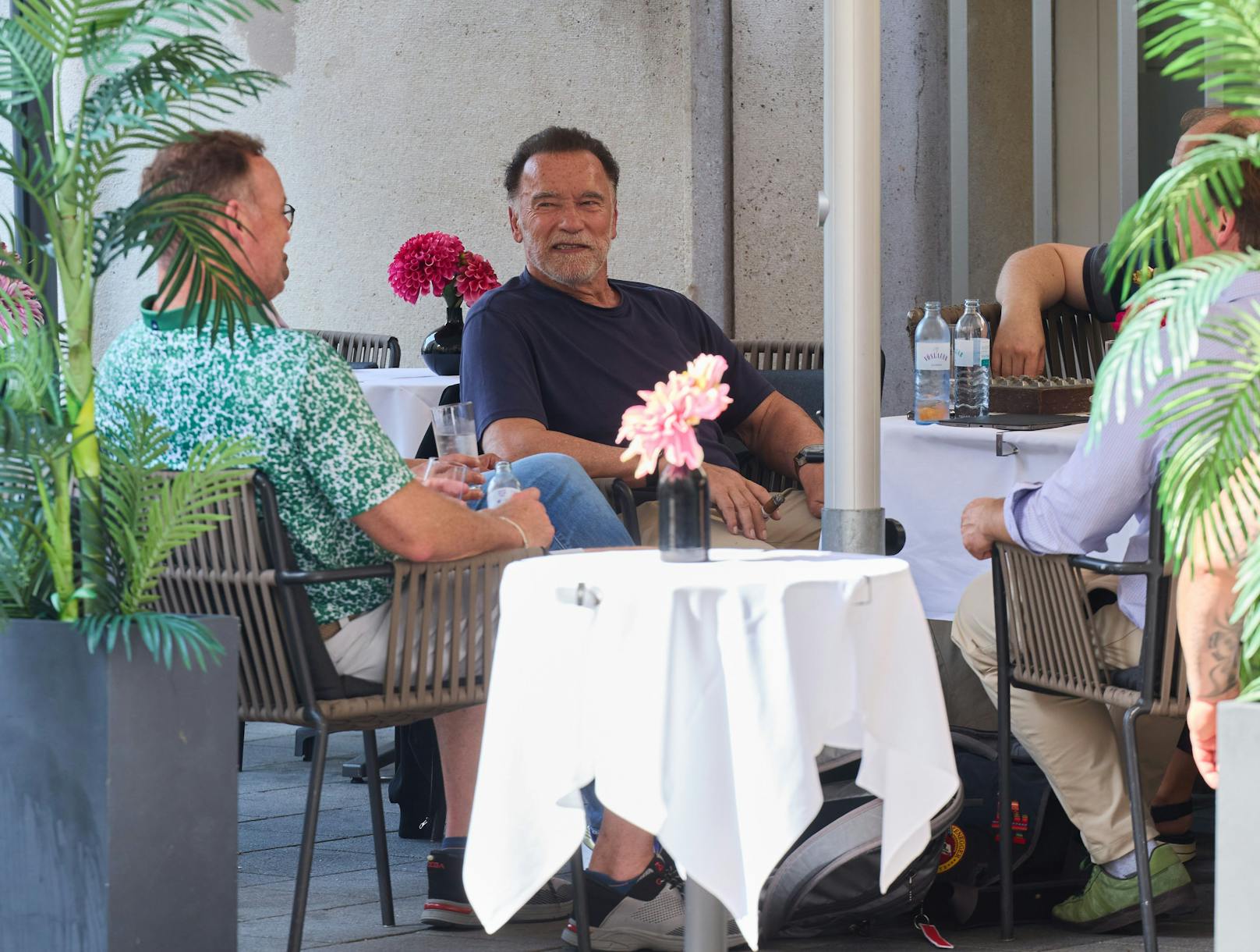Arnie mischt sich im Café des Hotels unter die Gäste. In der Hand wieder eine Zigarre.