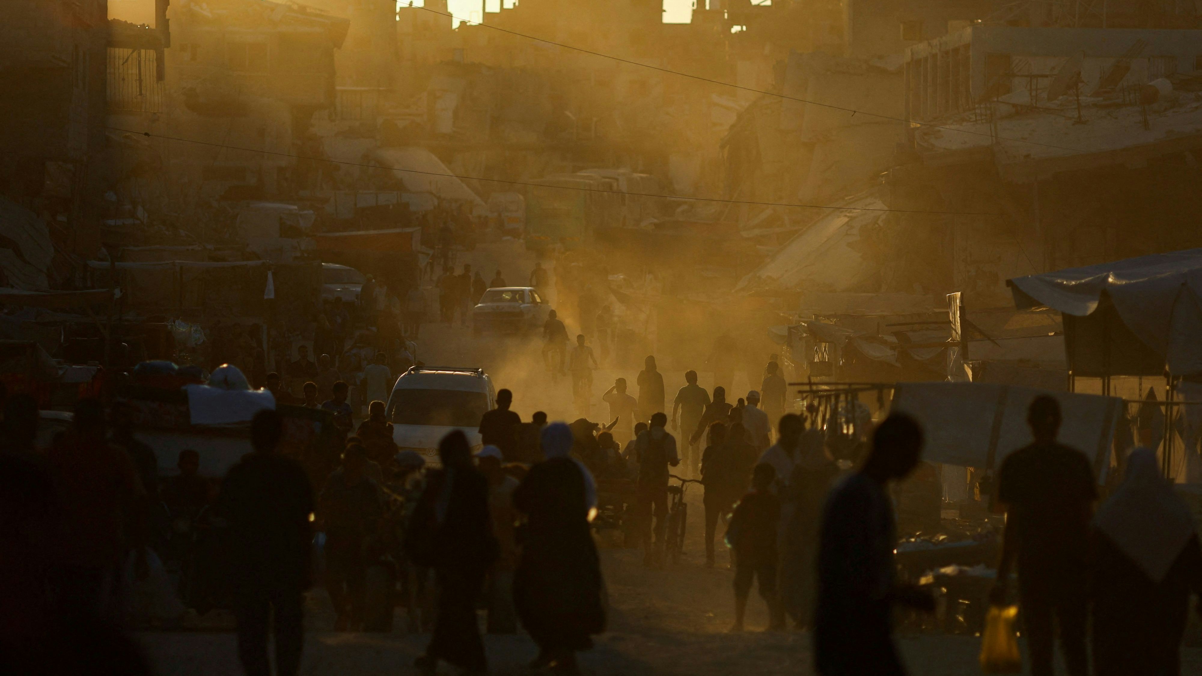 Inmitten des andauernden Konflikts zwischen Israel und der Hamas gehen Menschen am Sonntag in Khan Younis im südlichen Gazastreifen durch die Überreste eines Marktes nach einem israelischen Angriff.
