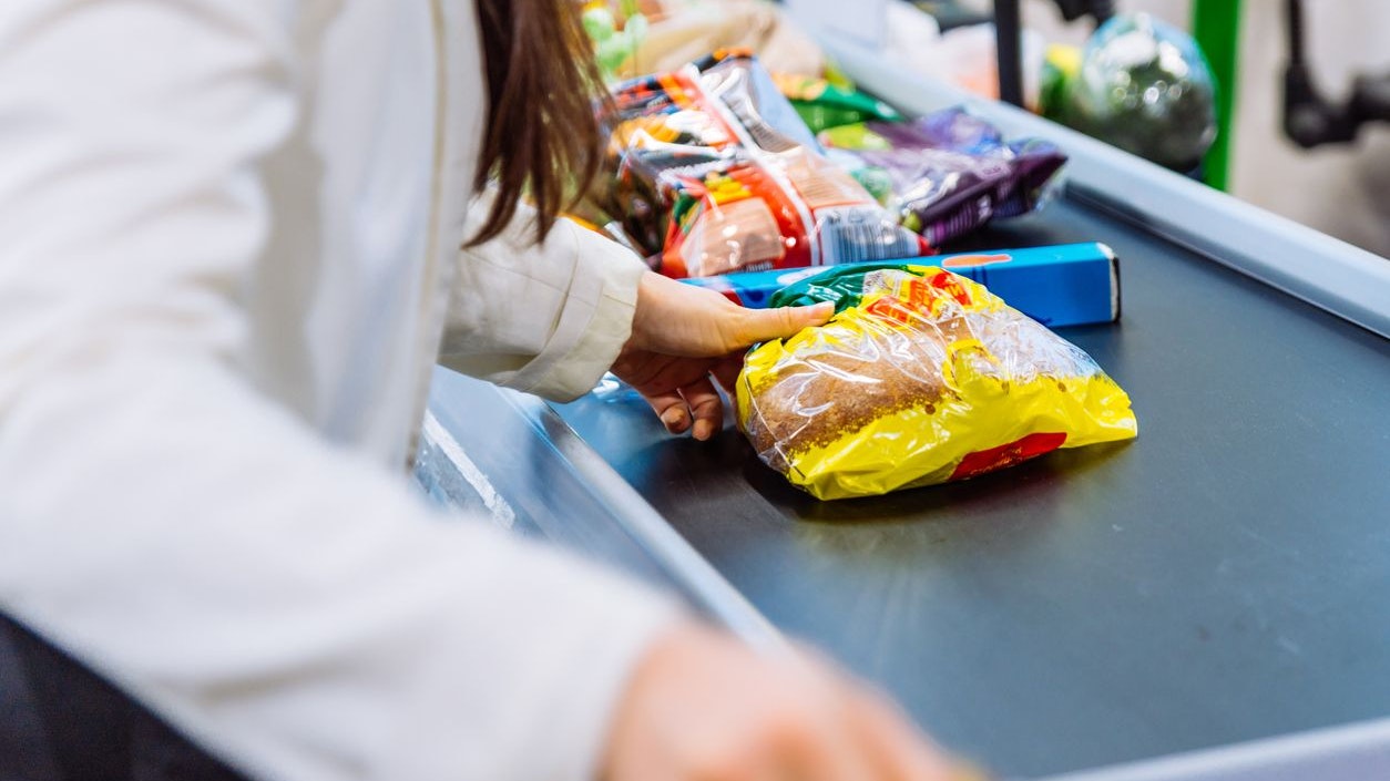 woman put products on the line near cashbox. grocery shopping concept