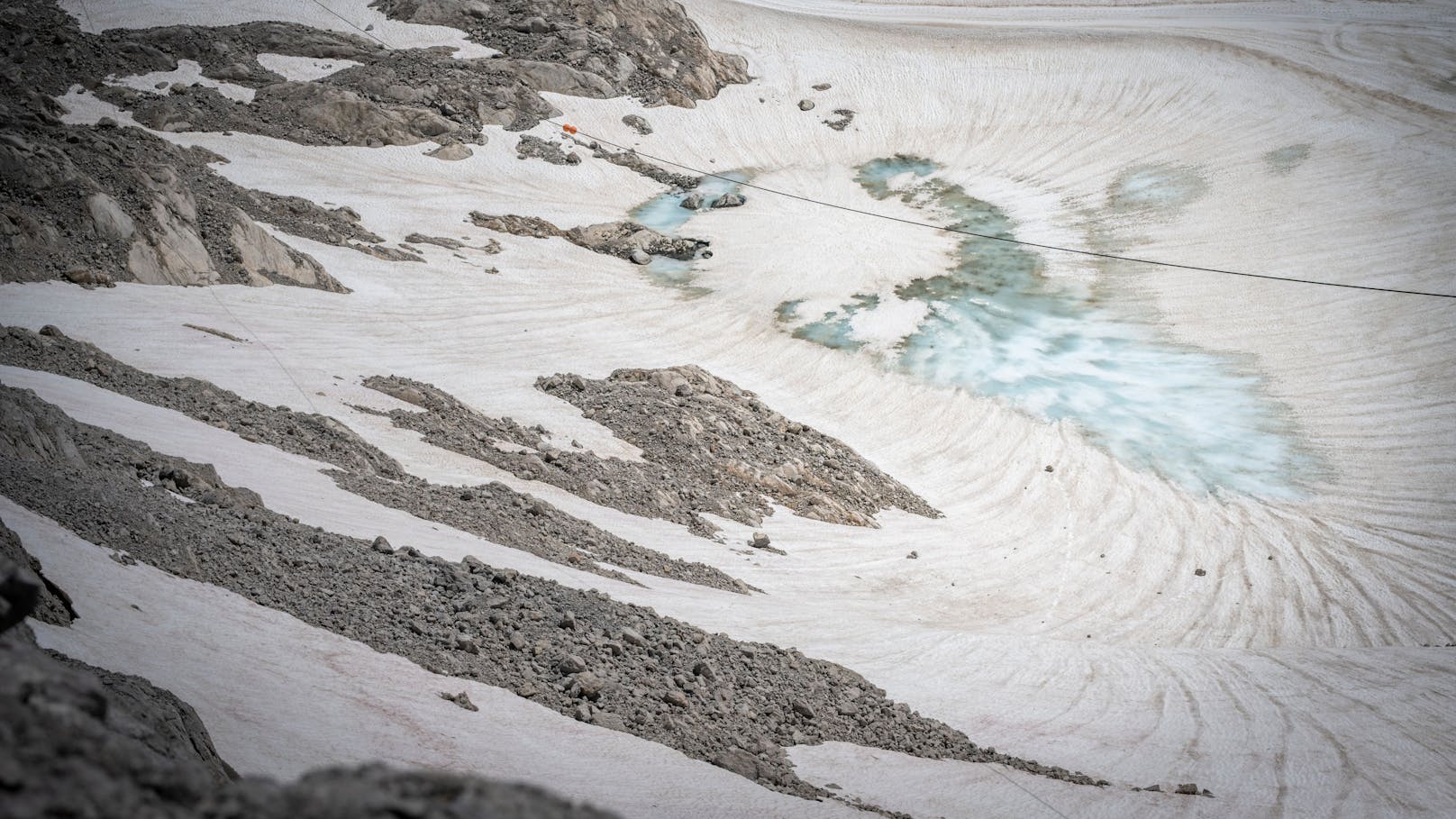 Blankes Eis (hellblau) am Schladminger Gletscher neben der Sessellift-Bergstation. Gut zu erkennen die Spuren, die das Schmelzwasser durch den aufliegenden Saharastaub zieht.