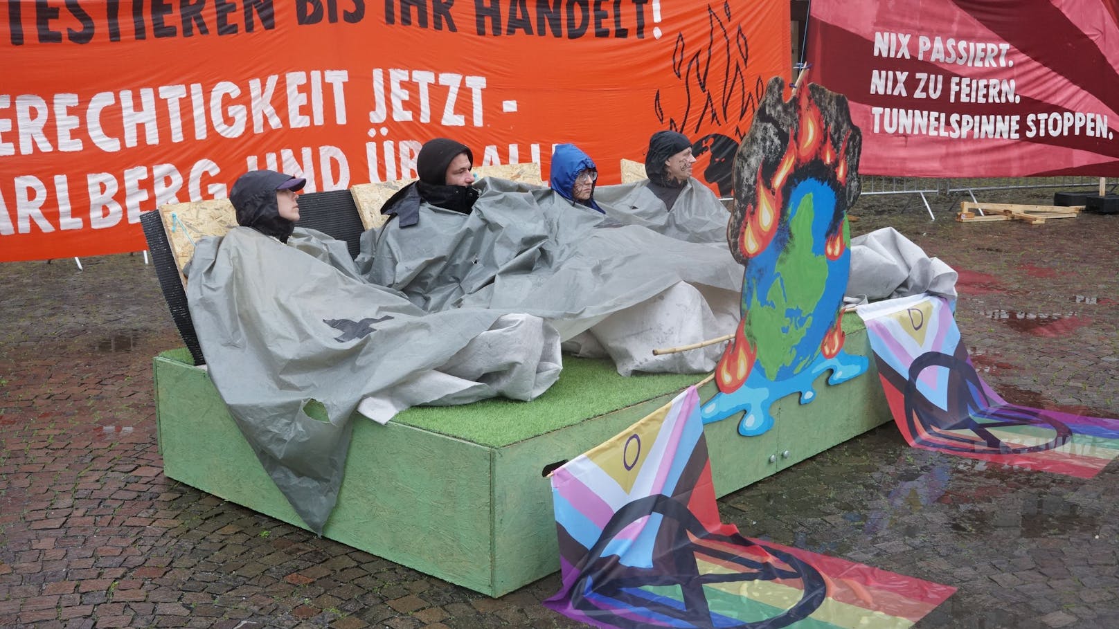 Mittwochfrüh hat die Vorarlberger Polizei die Blockade von "Extinction Rebellion" vor dem Landhaus Bregenz geräumt. Die Klimaaktivisten hatten sich an einer riesigen, brennenden und gleichzeitig ertrinkenden Erdkugel sowie einer großen Geburtstagstorte festgekettet.