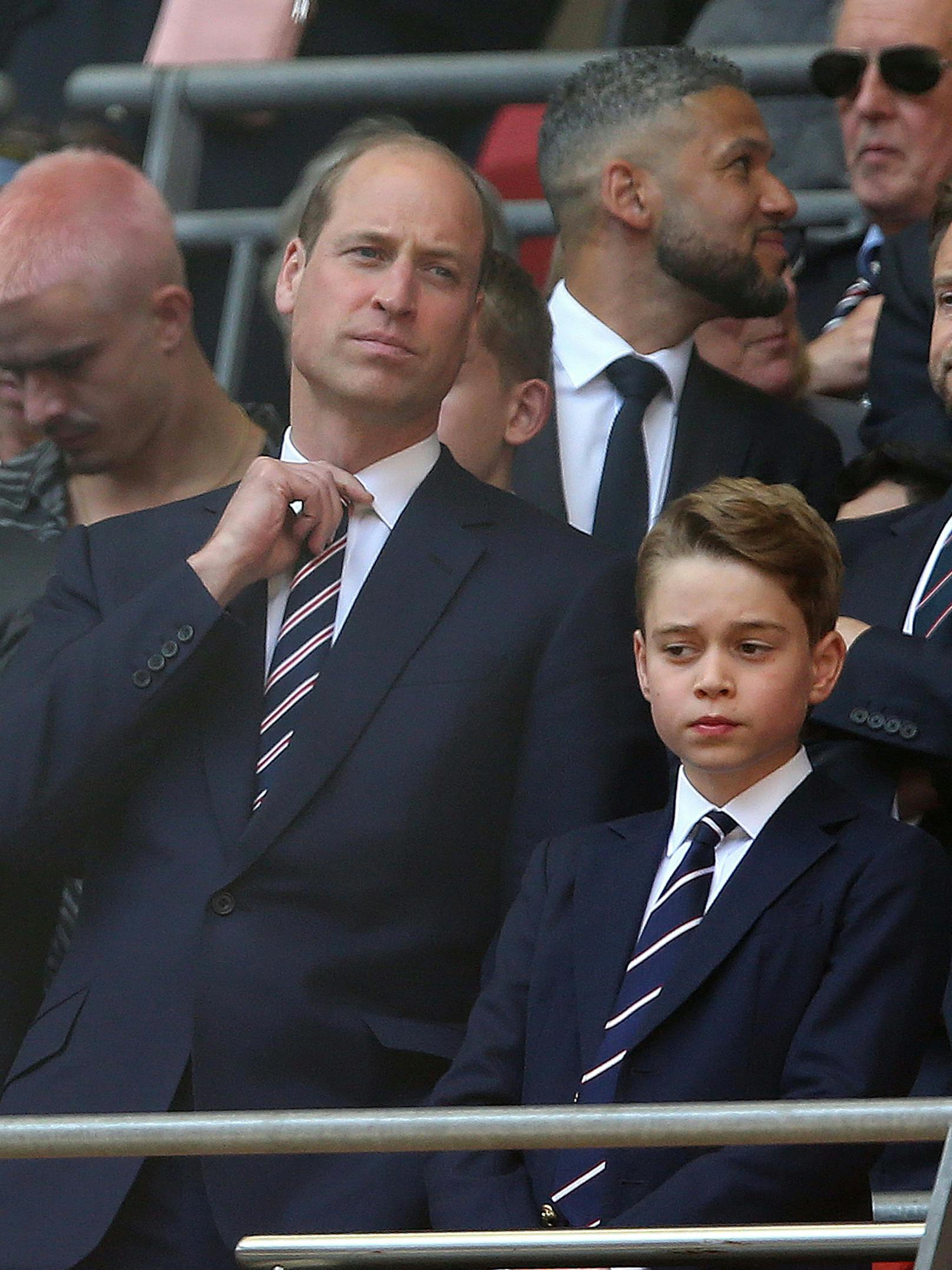 Prinz George mit Krawatte im Sportstadion.