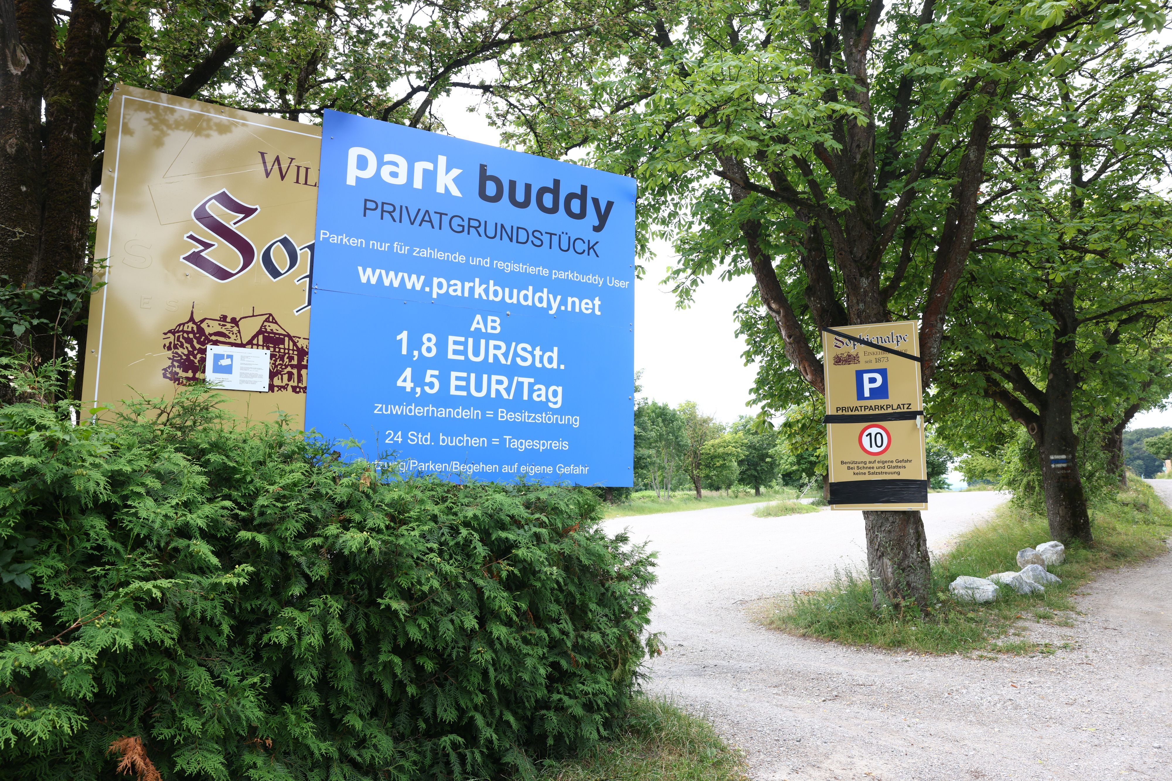 Ein Schild weist auf den kostenpflichtigen Parkplatz hin – gebucht werden kann nur über eine Homepage.