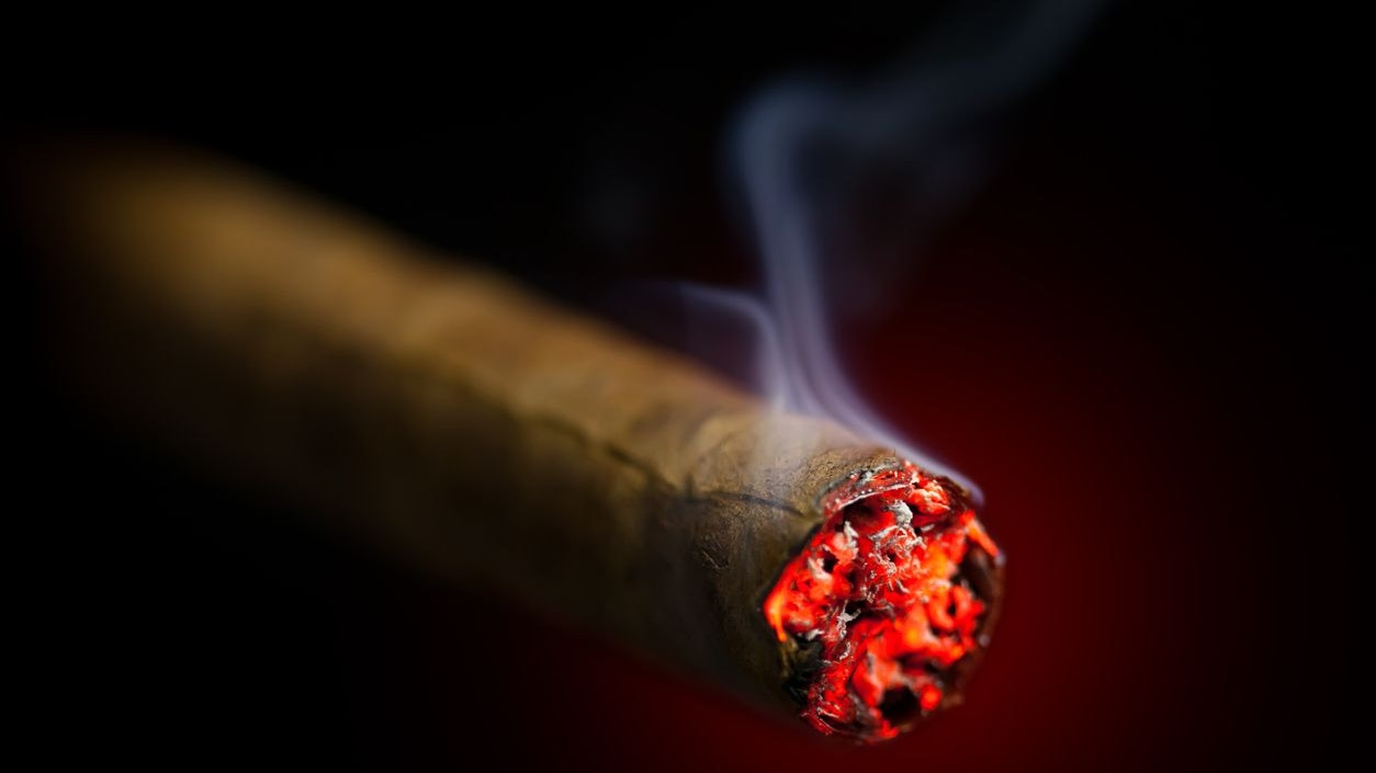 burning cigar on red glowing background