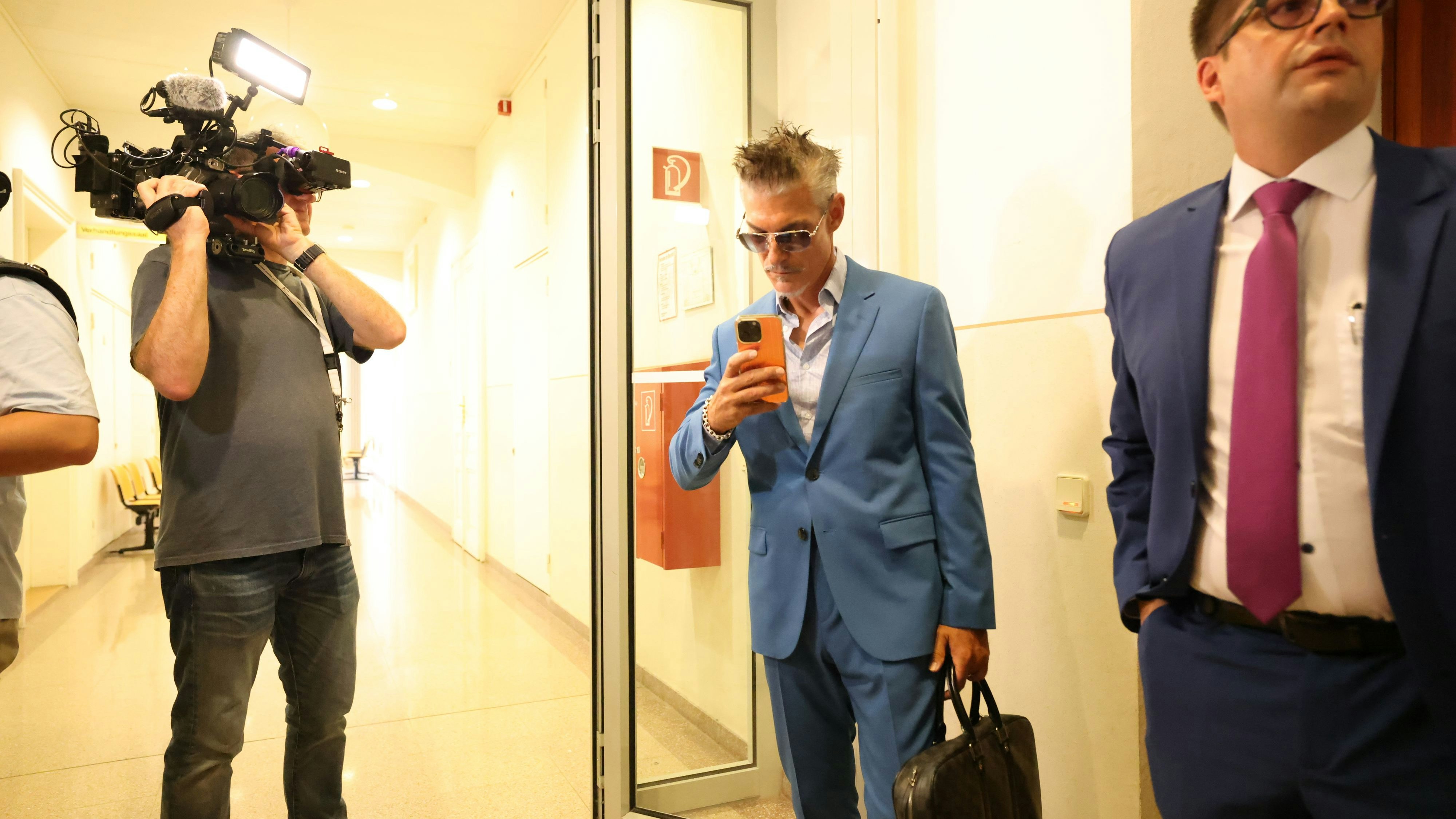 Goldene Handyhülle, getönte Brille: Kurz vor dem Prozess war laut seinem Anwalt die "Anspannung groß".