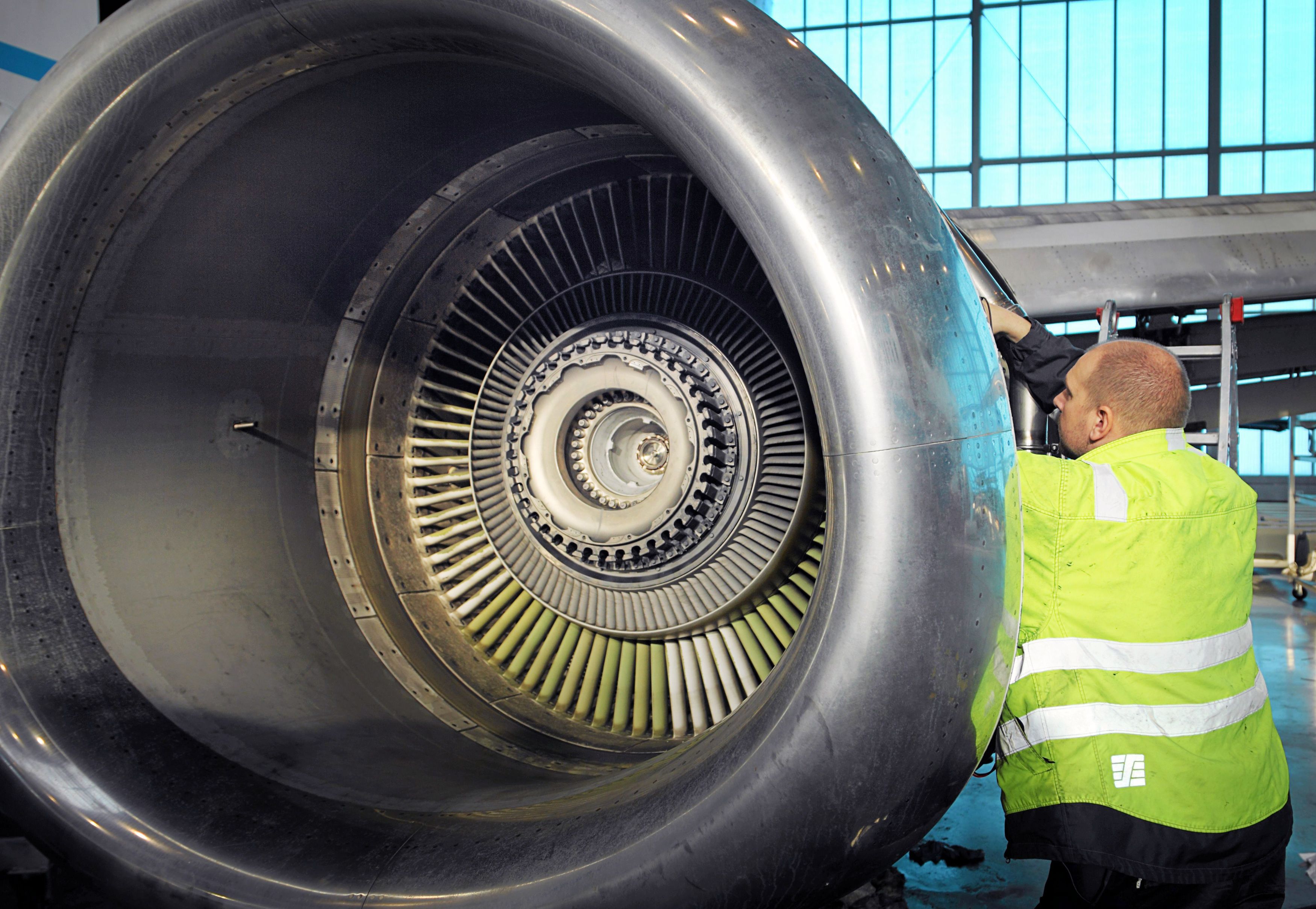 Ein Mechaniker bei Arbeiten am Triebwerk einer Boeing 737-500. Symbolbild.