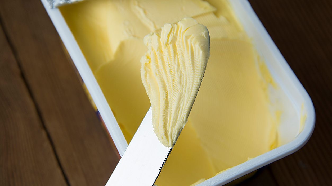 Whipped butter in plastic container with knife, butter for cooking and sandwiches.