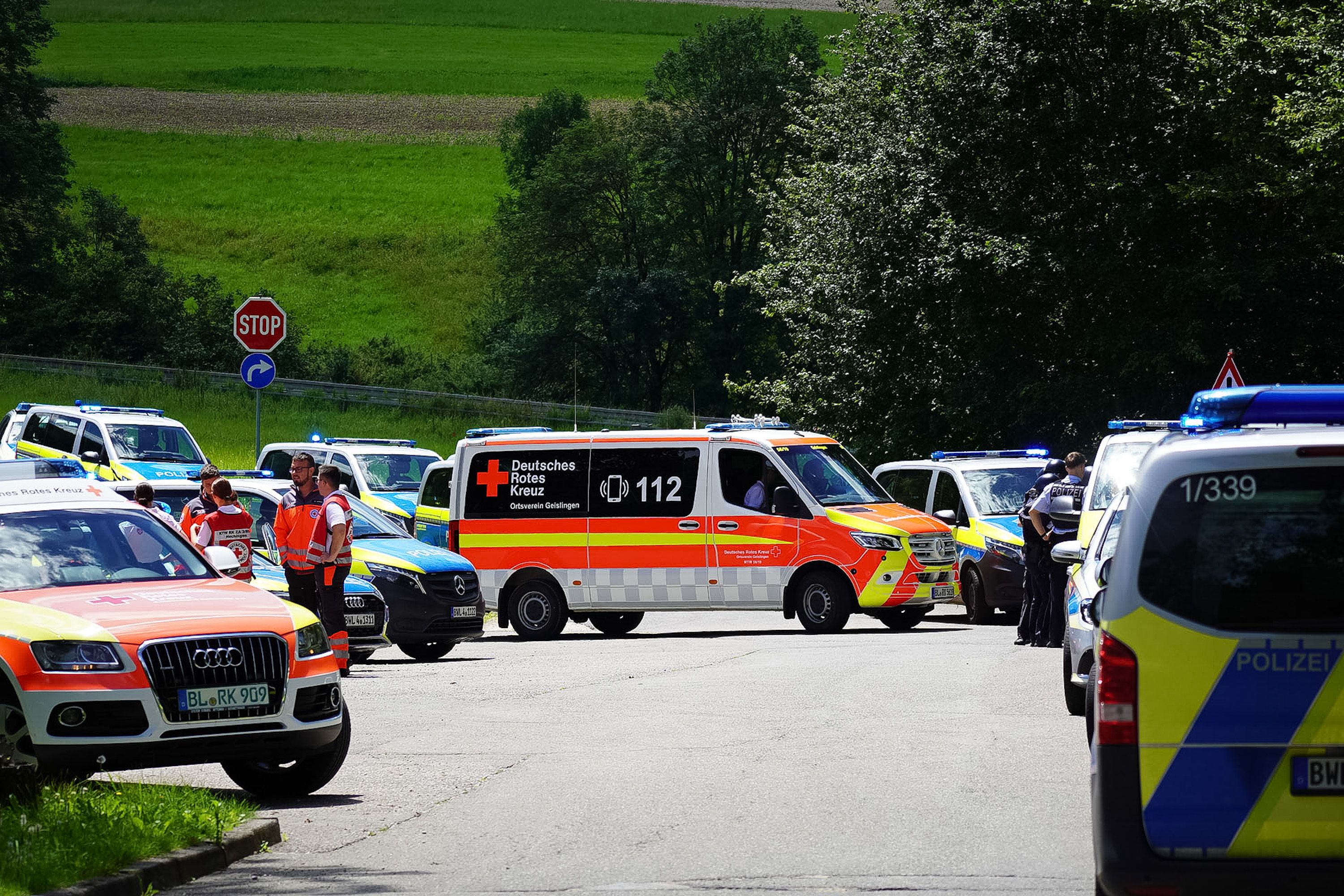 Rettungskräfte und Polizei stehen während eines Einsatzes in Albstadt-Lautlingen auf einer Straße. Polizeibeamte haben bei einem Großeinsatz in Albstadt auf der Schwäbischen Alb mehrere Tote und Verletzte gefunden.