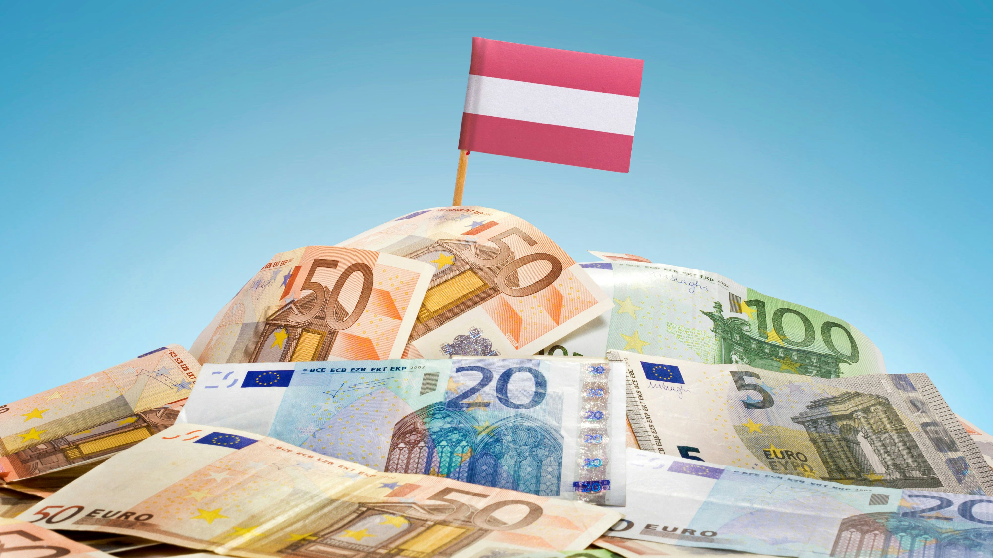 The national flag of Austria sticking in a pile of mixed european banknotes.(series)