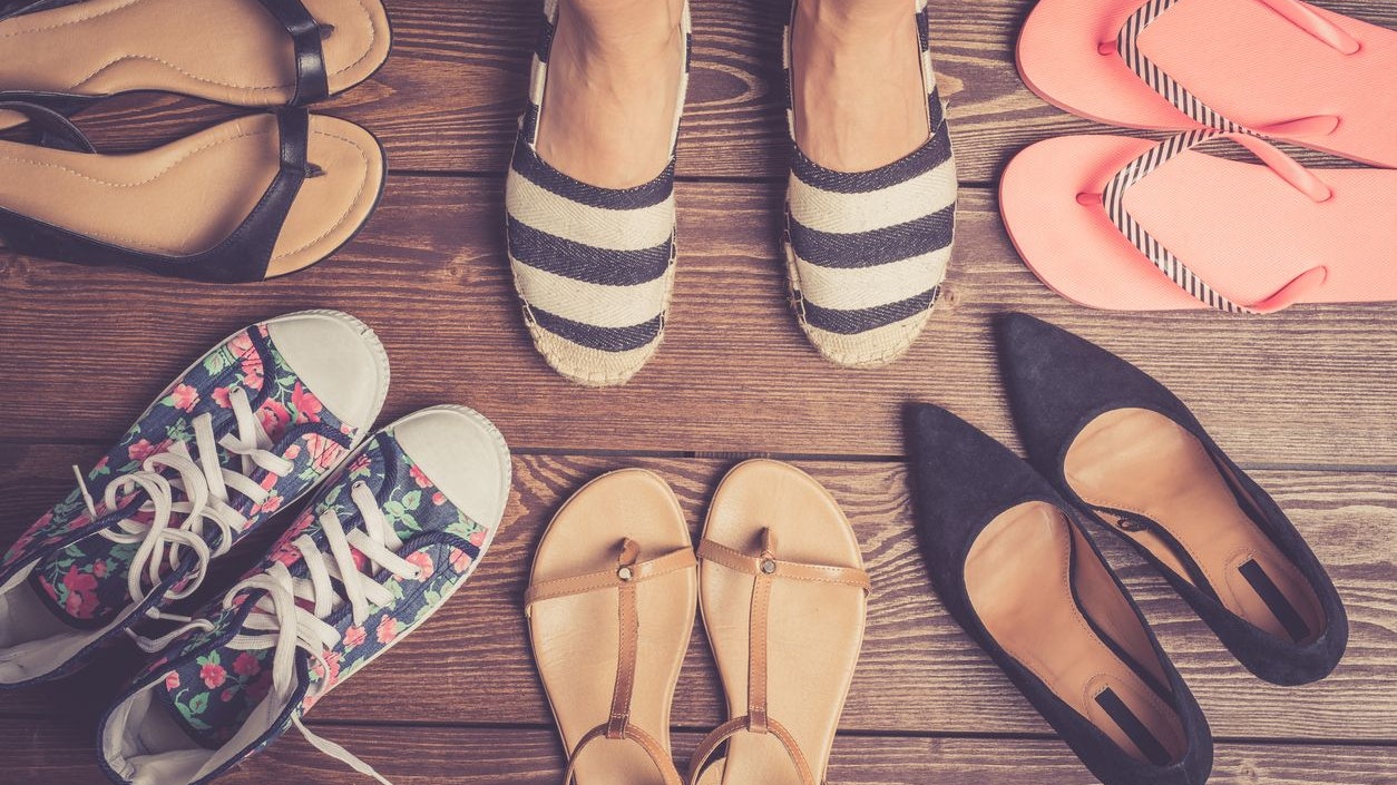Collection of female shoes on wooden floor. Fashion background
