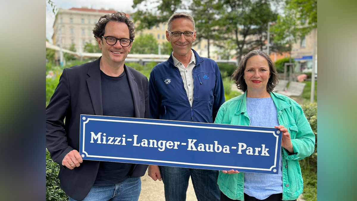 Grüner Bezirksvorsteher Markus Reiter präsentiert gemeinsam mit der Bezirksvertretung das neue Schild.