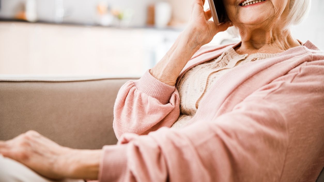 Close up of joyful elderly lady having phone conversation stock photo