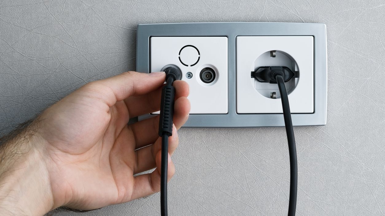 Viele TV-Zuseher sitzen vor einem schwarzen Bildschirm. Symbolbild.