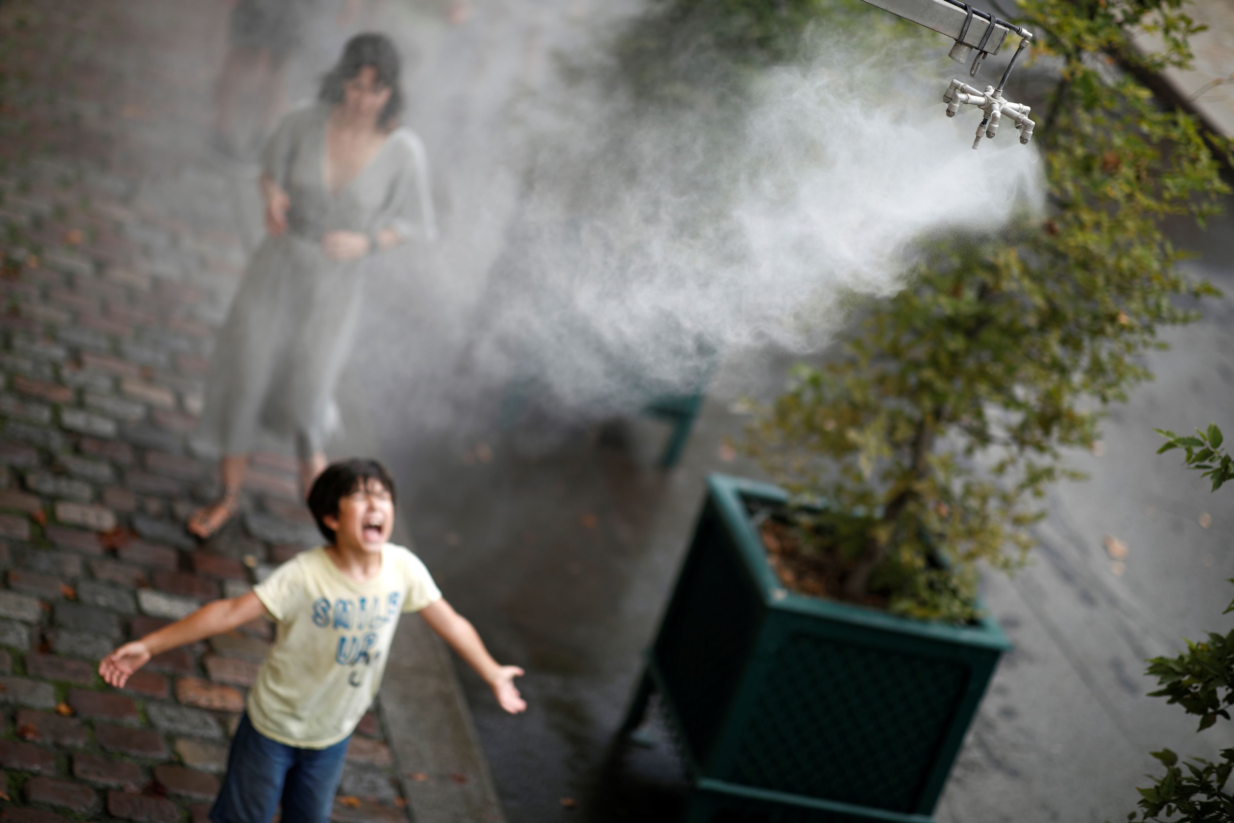 Gnadenlose Temperaturen: Ein Bub kühlt sich während der Hitzewelle in Paris ab