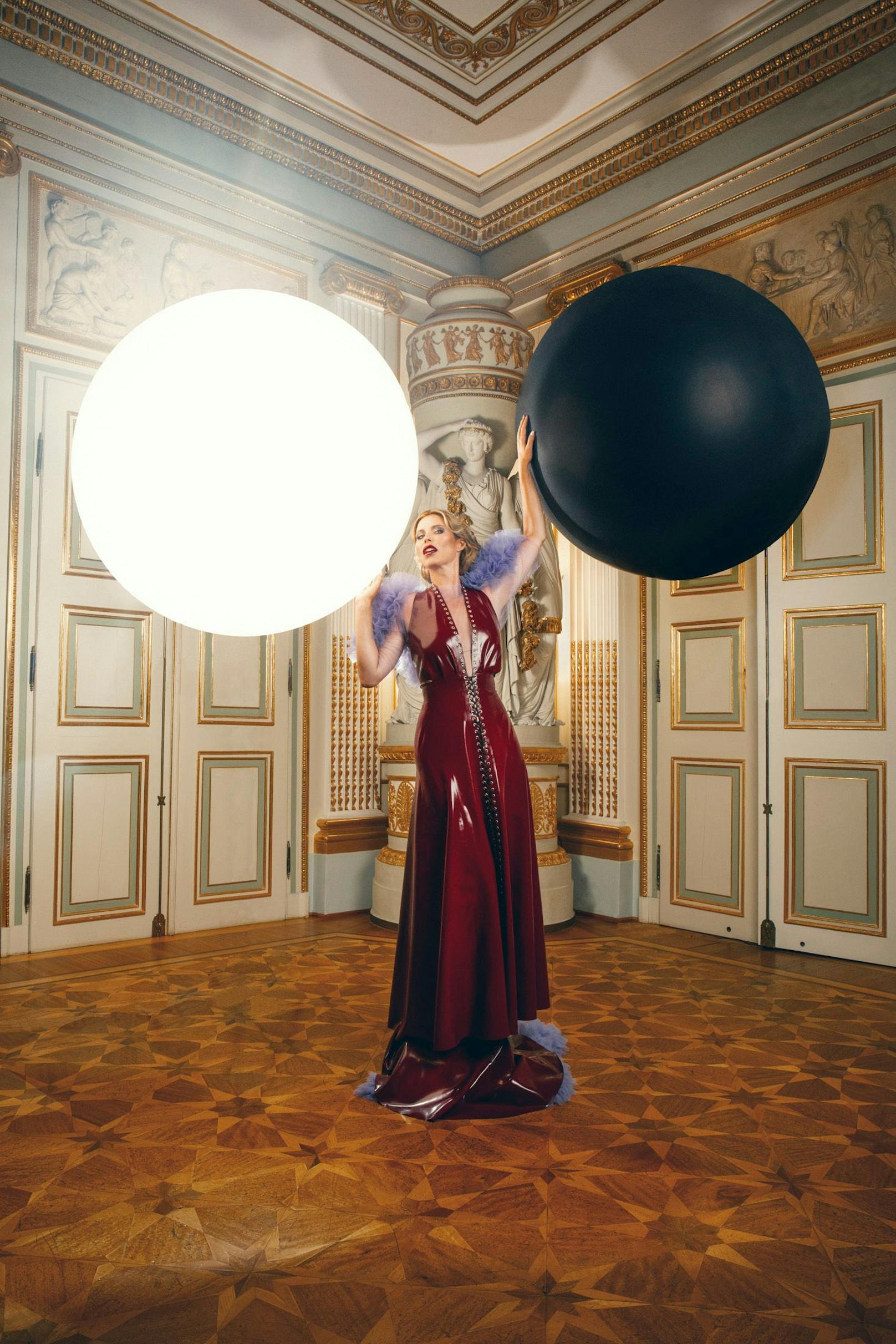 Im einzigartigen Shooting verkörperte Kiera Chaplin eine moderne Inkarnation der Göttin Justitia, indem sie symbolisch zwei große Ballons balancierte und damit die Harmonisierung gegensätzlicher Welten darstellte. 