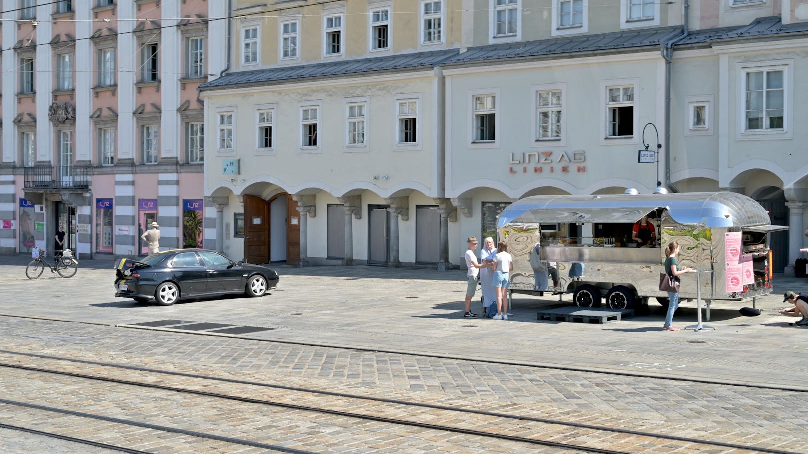 Auto und Foodtruck vor dem Alten Rathaus sind Teil der Szene.