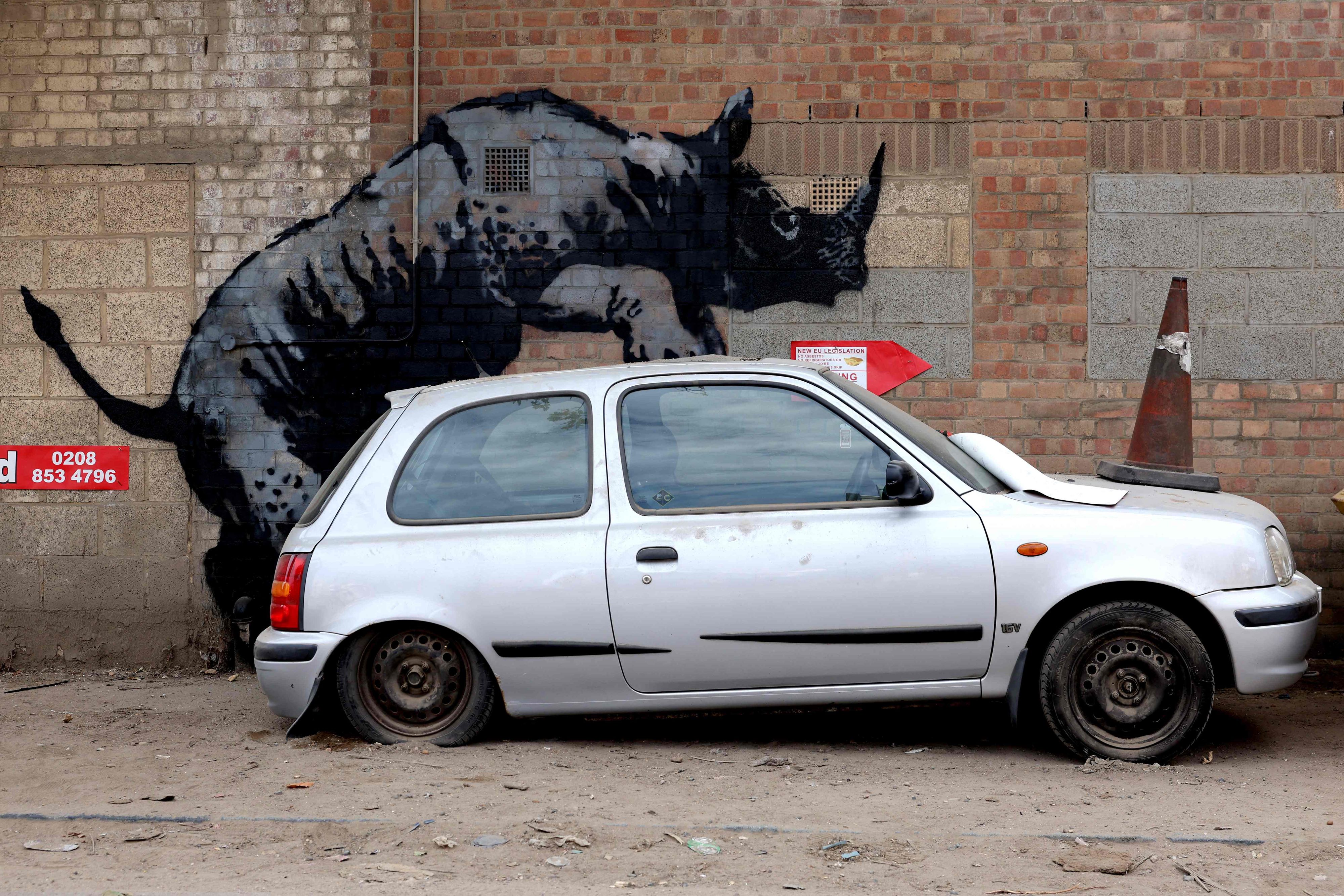 Das achte Kunstwerk des Straßenkünstlers Banksy, das innerhalb von acht Tagen veröffentlicht wurde, zeigt ein Nashorn, das ein Auto besteigt, an einer Wand in Charlton, London.