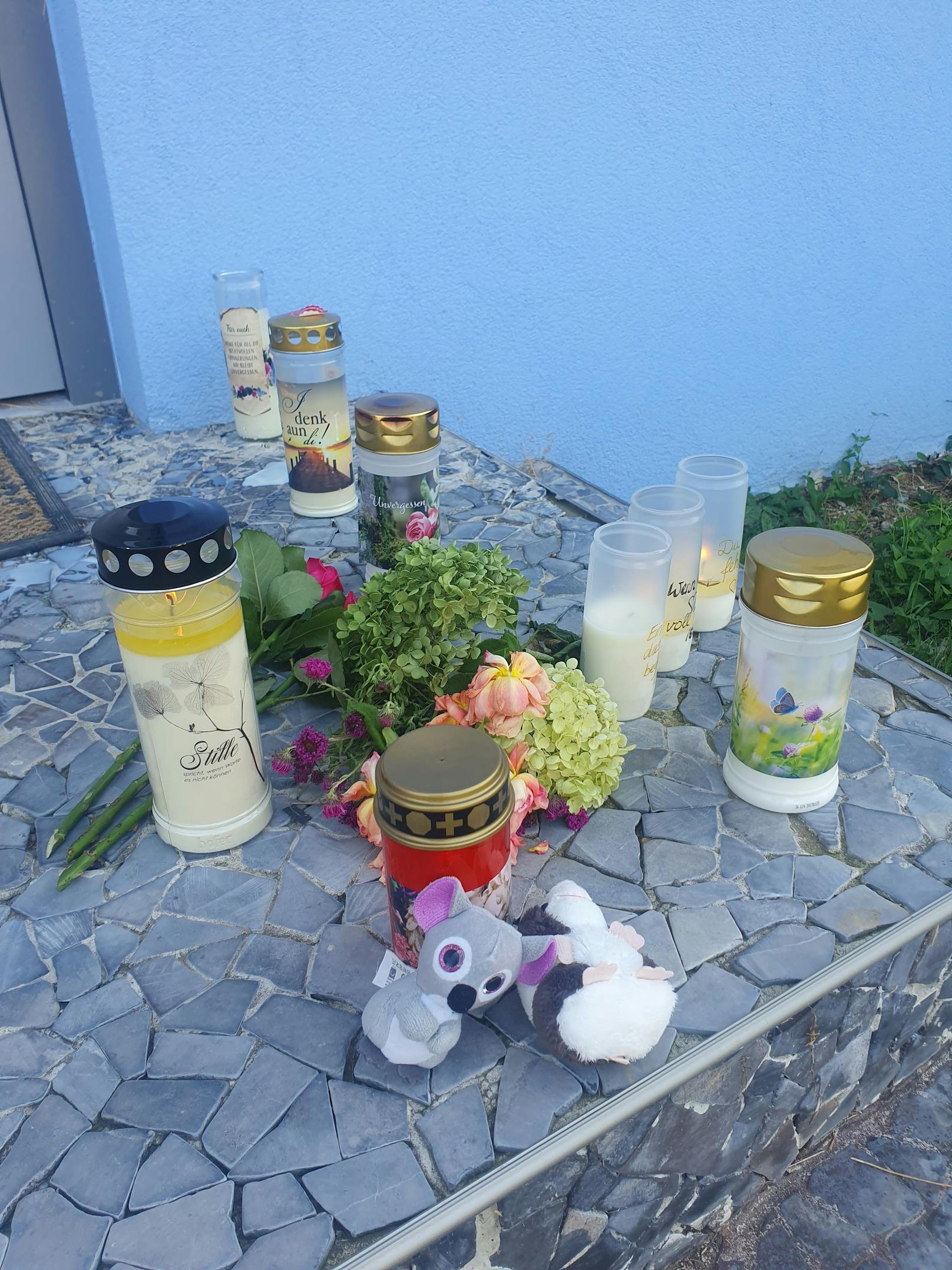 Kleine Stofftiere, Kerzen, Blumen im Eingangsbereich