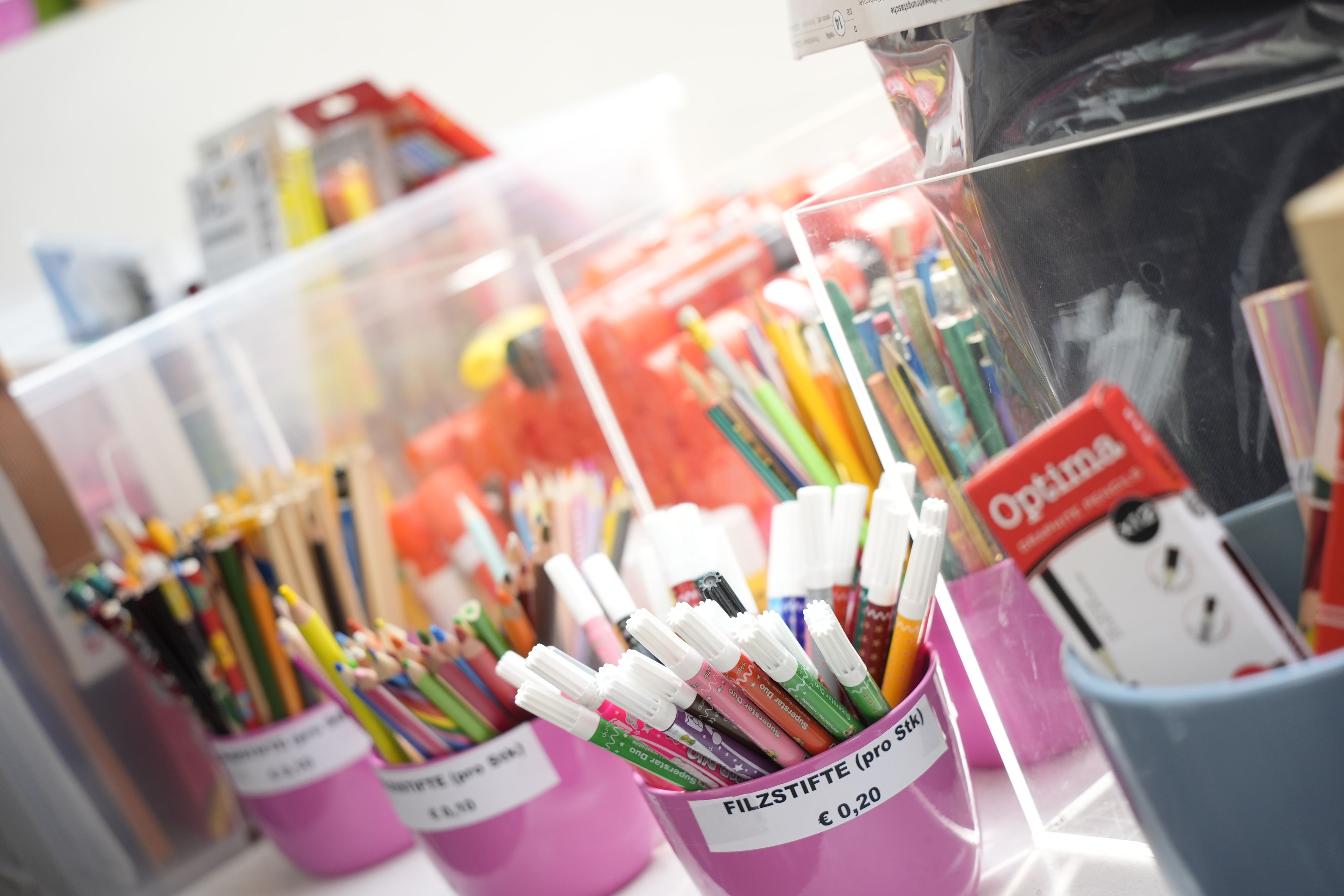 Mutter Aya kauft mit Tochter Laya und Sohn Aws Schulsachen im carla-Shop der Caritas.