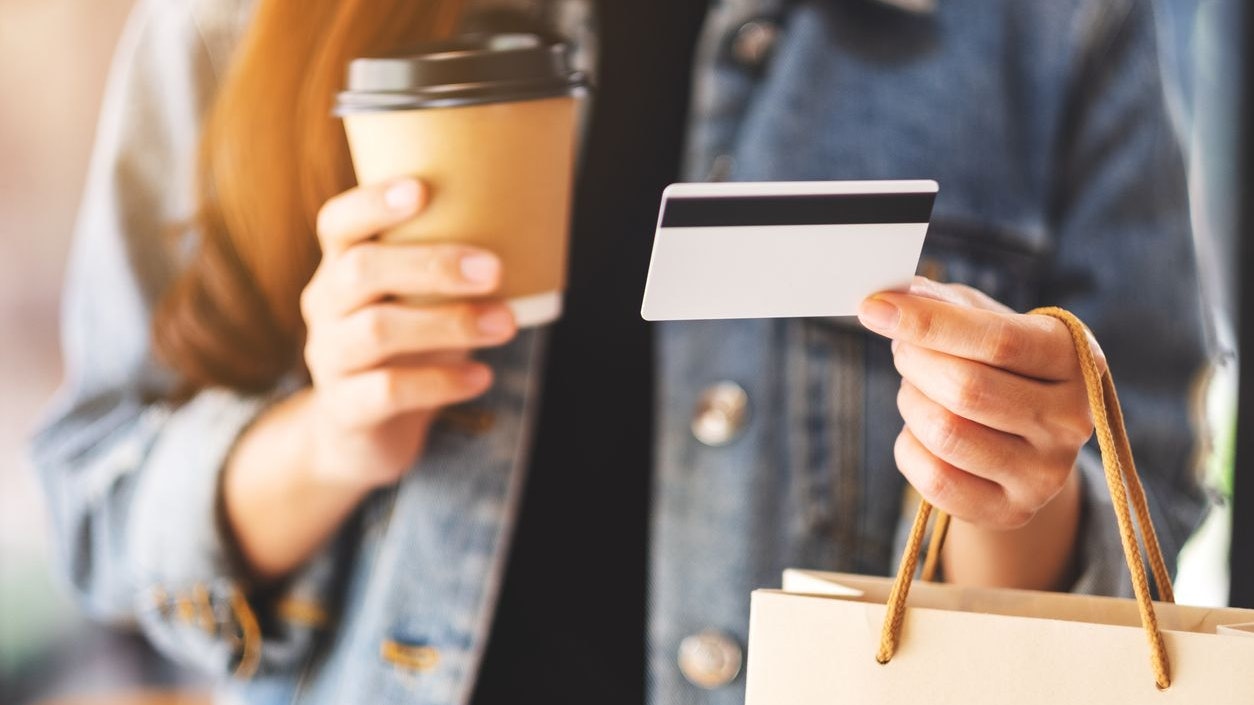 A woman holding shopping bags , credit card and coffee cup for online shopping concept