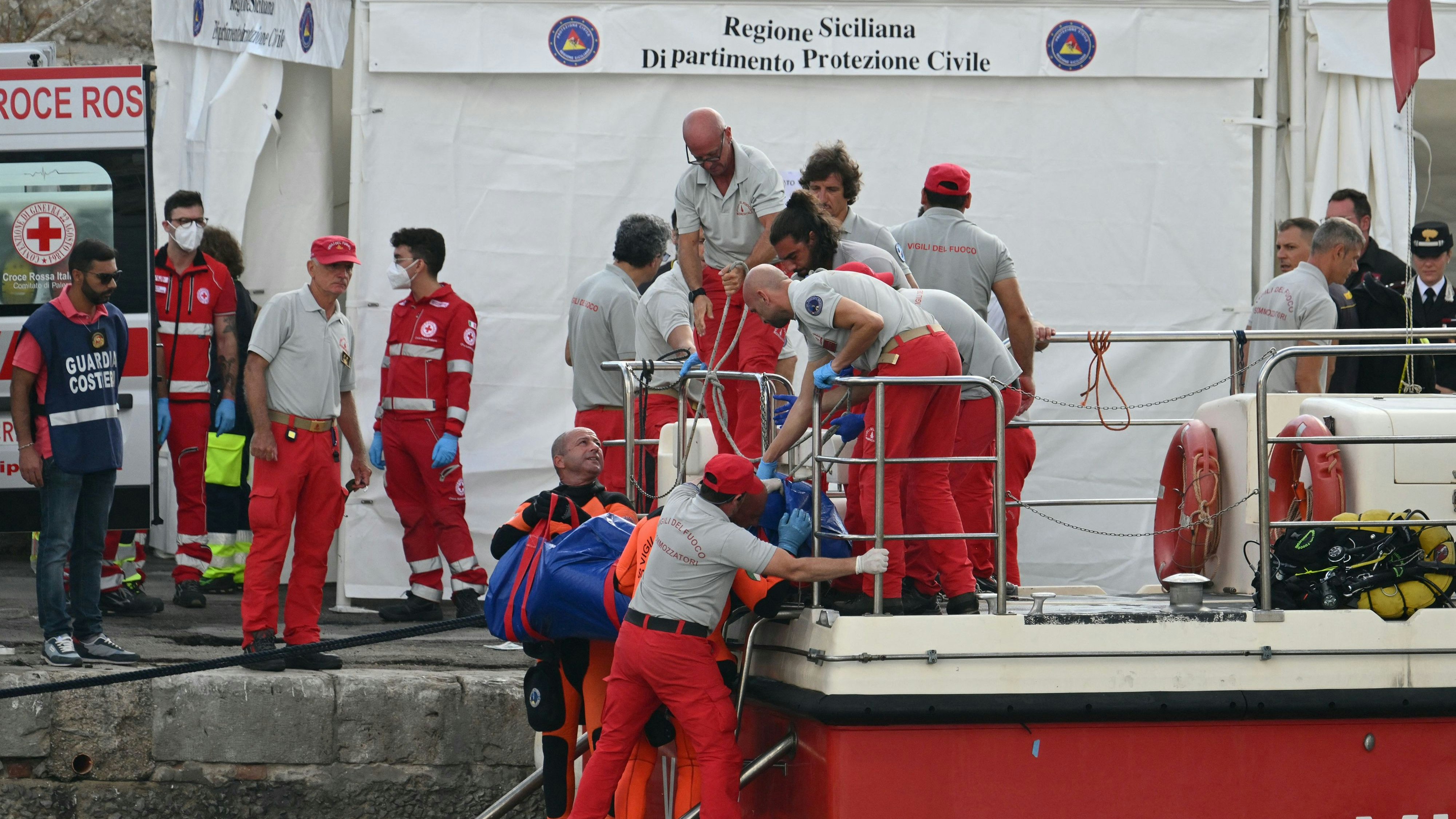 Download von www.picturedesk.com am 22.08.2024 (09:33).  Rescuers carry a body after divers return in Porticello harbor near Palermo, on August 22, 2024, three days after the British-flagged luxury yacht Bayesian sank. Divers searching for six missing people following the sinking of a superyacht off Sicily in a storm have found fifth bodies. The Bayesian, which had 22 people aboard including 10 crew, was anchored some 700 metres from port before dawn when it was struck by a waterspout. Among the six missing were UK tech entrepreneur Mike Lynch and his 18-year-old daughter Hannah, and Jonathan Bloomer, the chair of Morgan Stanley International, and his wife Judy. (Photo by Alberto PIZZOLI / AFP) - 20240822_PD2465 - Rechteinfo: Rights Managed (RM) Nur für redaktionelle Nutzung! Werbliche Nutzung erfordert Freigabe: bitte schicken Sie uns eine Anfrage.